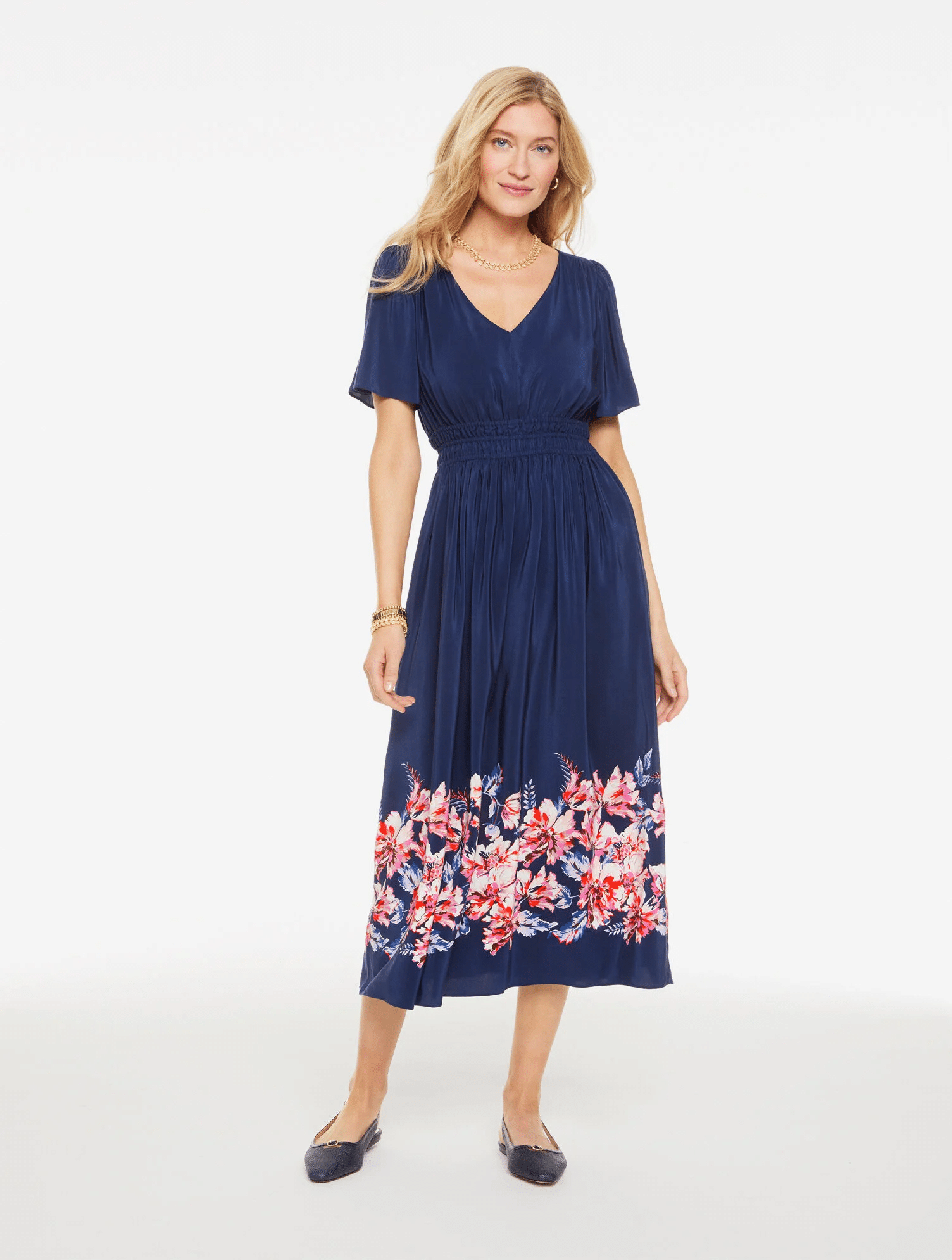 Woman in blue fit and flare dress with floral hem.