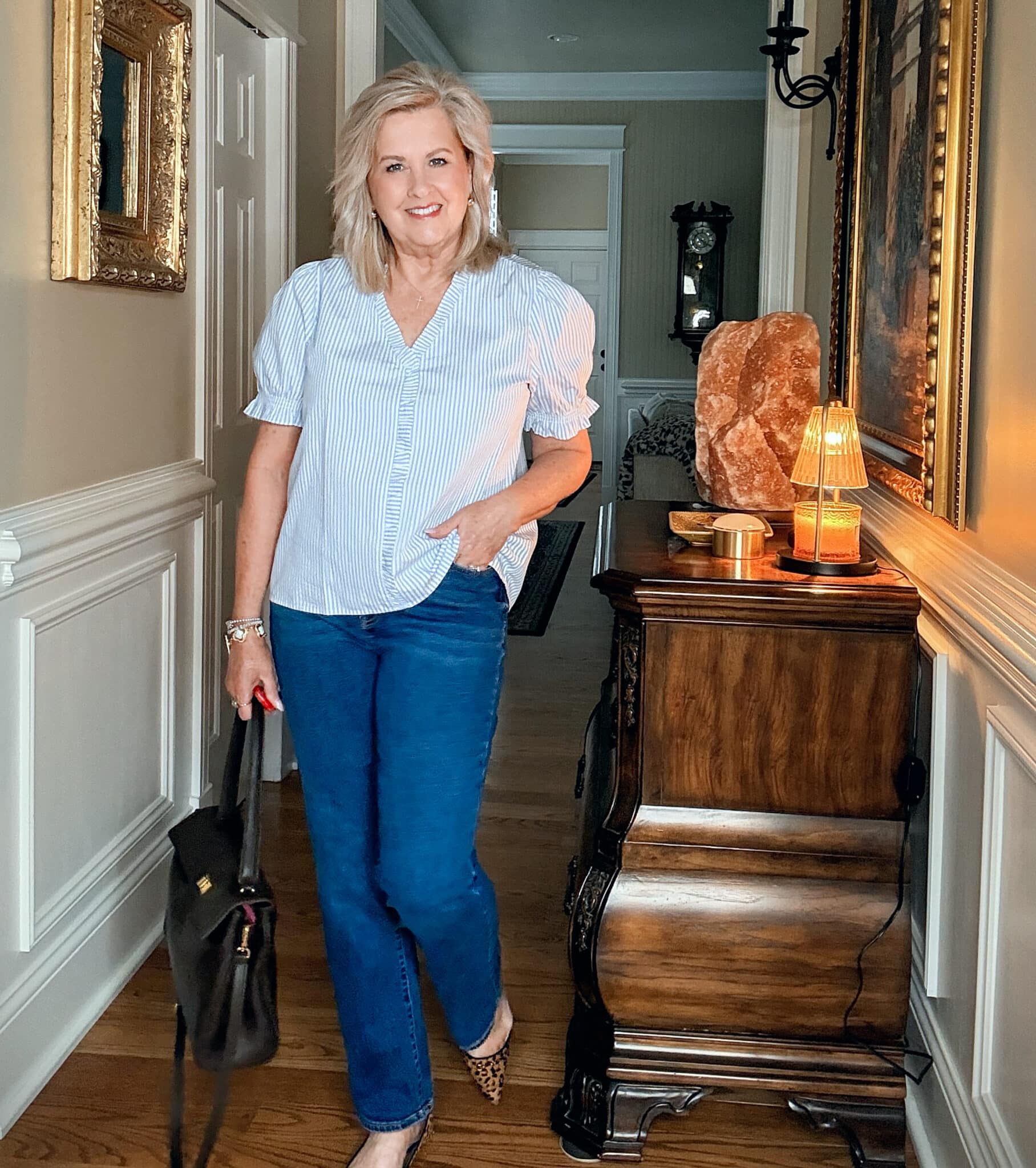 Simple outfit ideas for women over 50. Tania Stephens in classic navy jeans and a light pinstripe blouse.