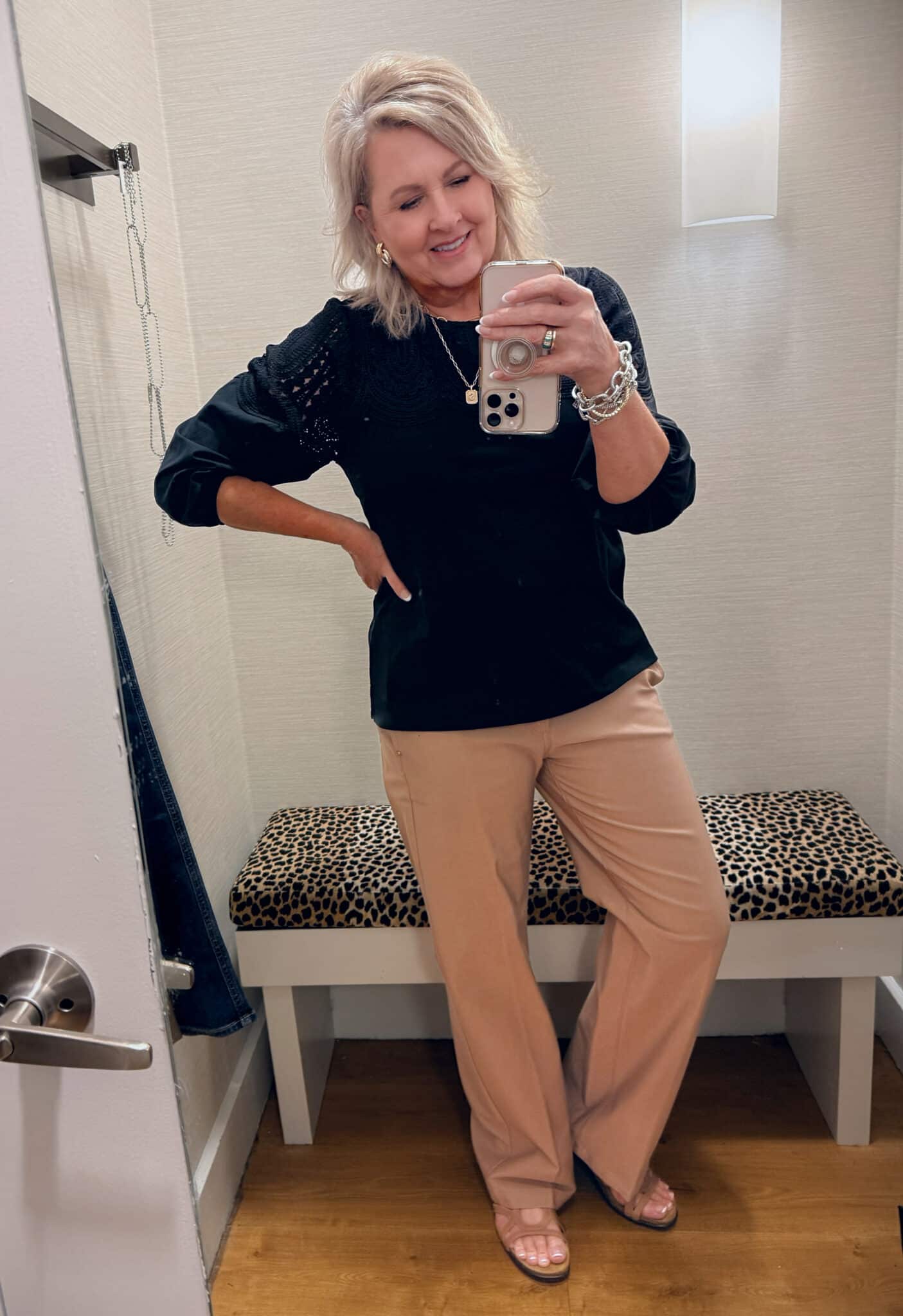 Tania wearing a Chico's black sweater with a lace detail and brown pants
