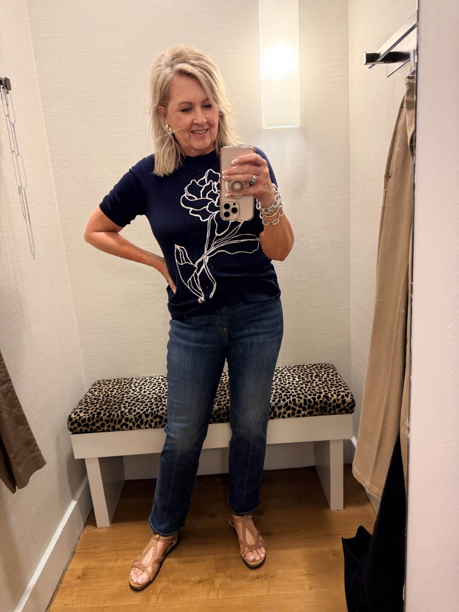 Tania wearing a Chico's navy sweater with a embroidered flower and jeans