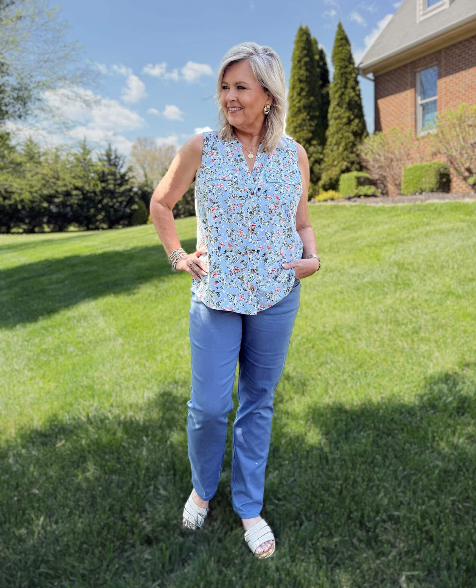 Tania from 50 is not old, is wearing a sleeveless floral shirt with blue pants from Kohls