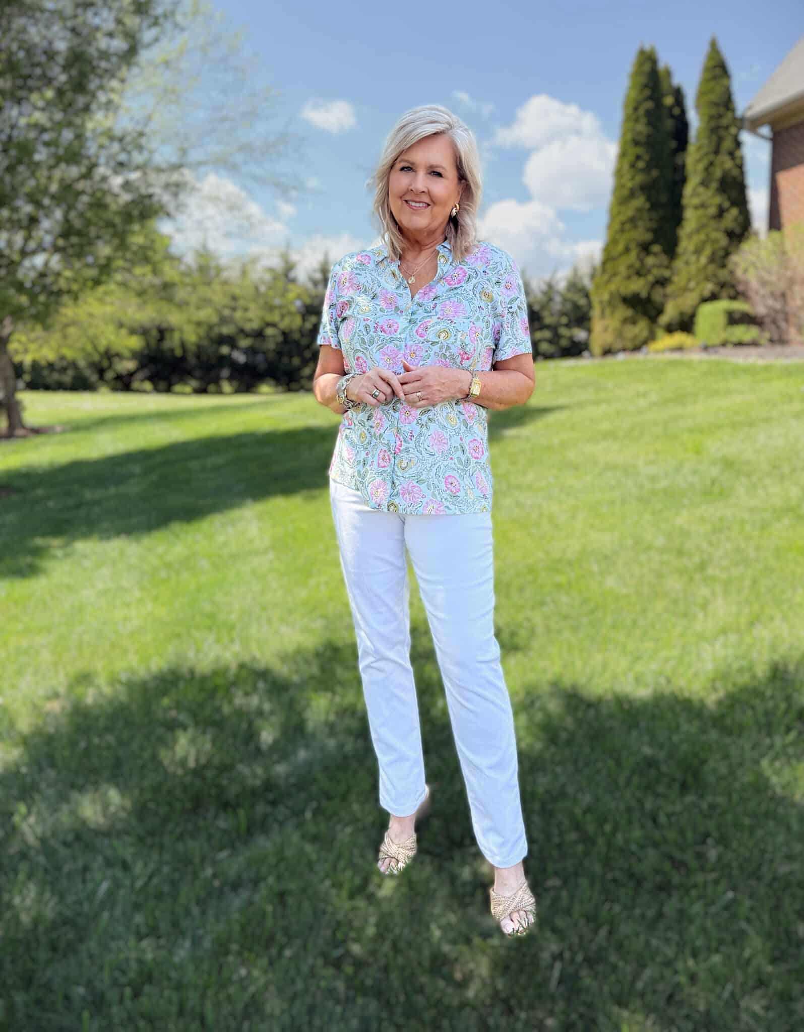 Tania from 50 is not old, is wearing a floral shirt with white jeans from Kohls