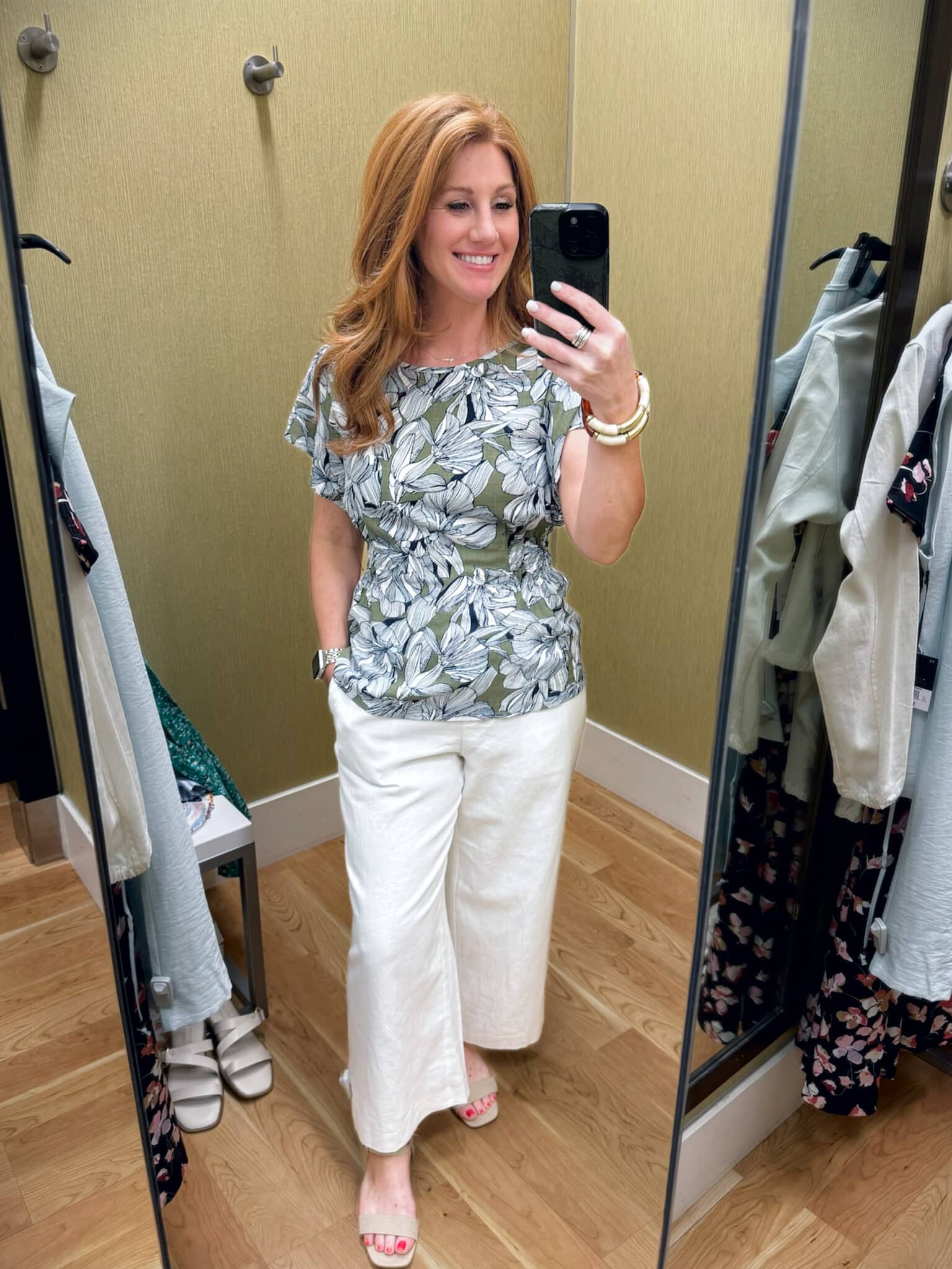 Stephanie wearing a pair of white pants and a printed wrap top from Kohl's
