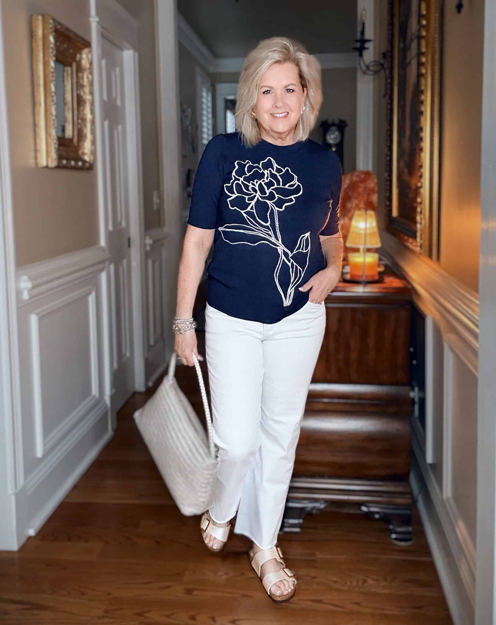 Tania wearing a navy and white floral sweater with white jeans for spring