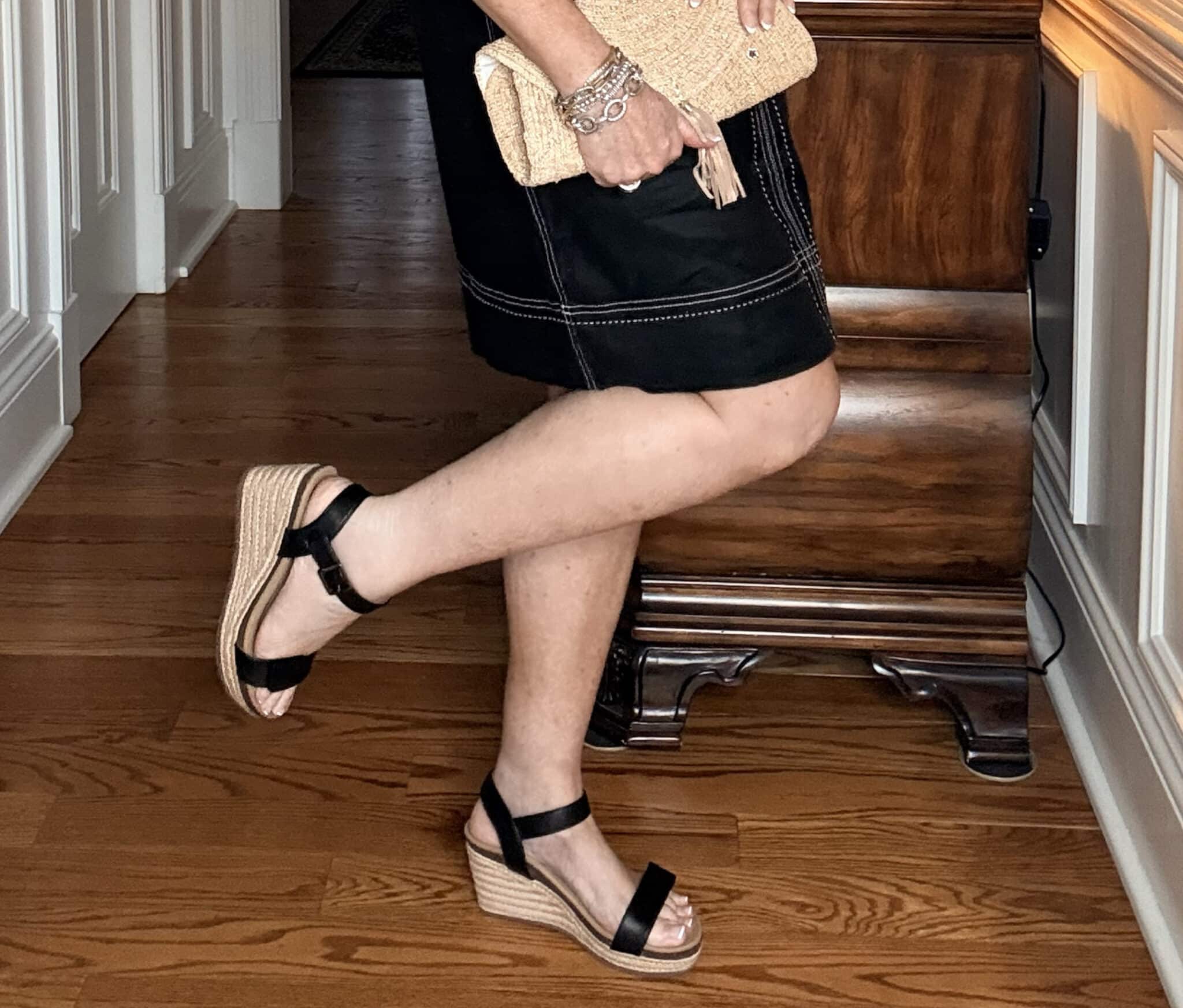Tania wearing a Tommy Bahama black sheath dress with black wedge shoes
