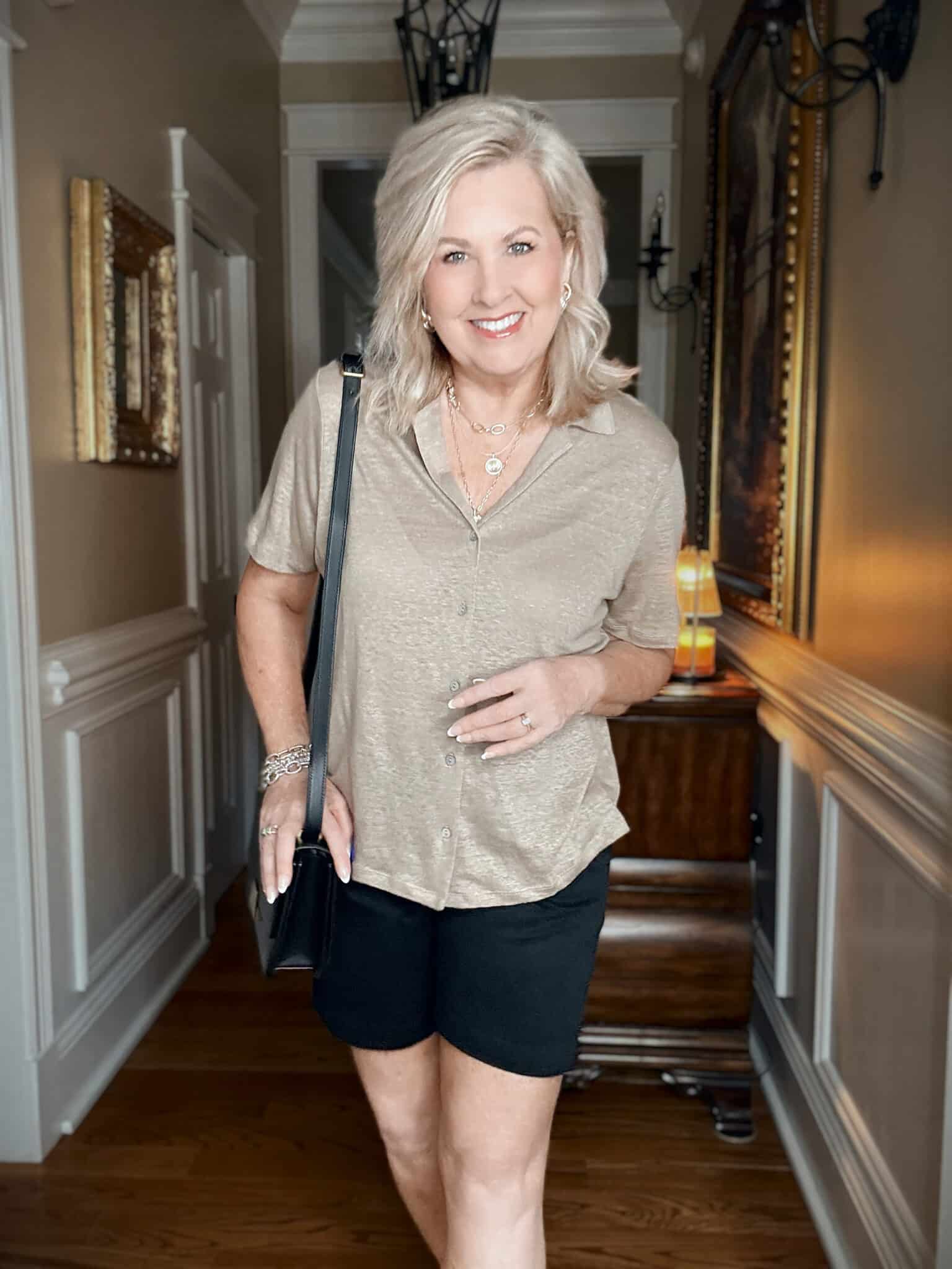 Tania wearing a Tommy Bahama tan linen button up shirt with black shorts for vacation