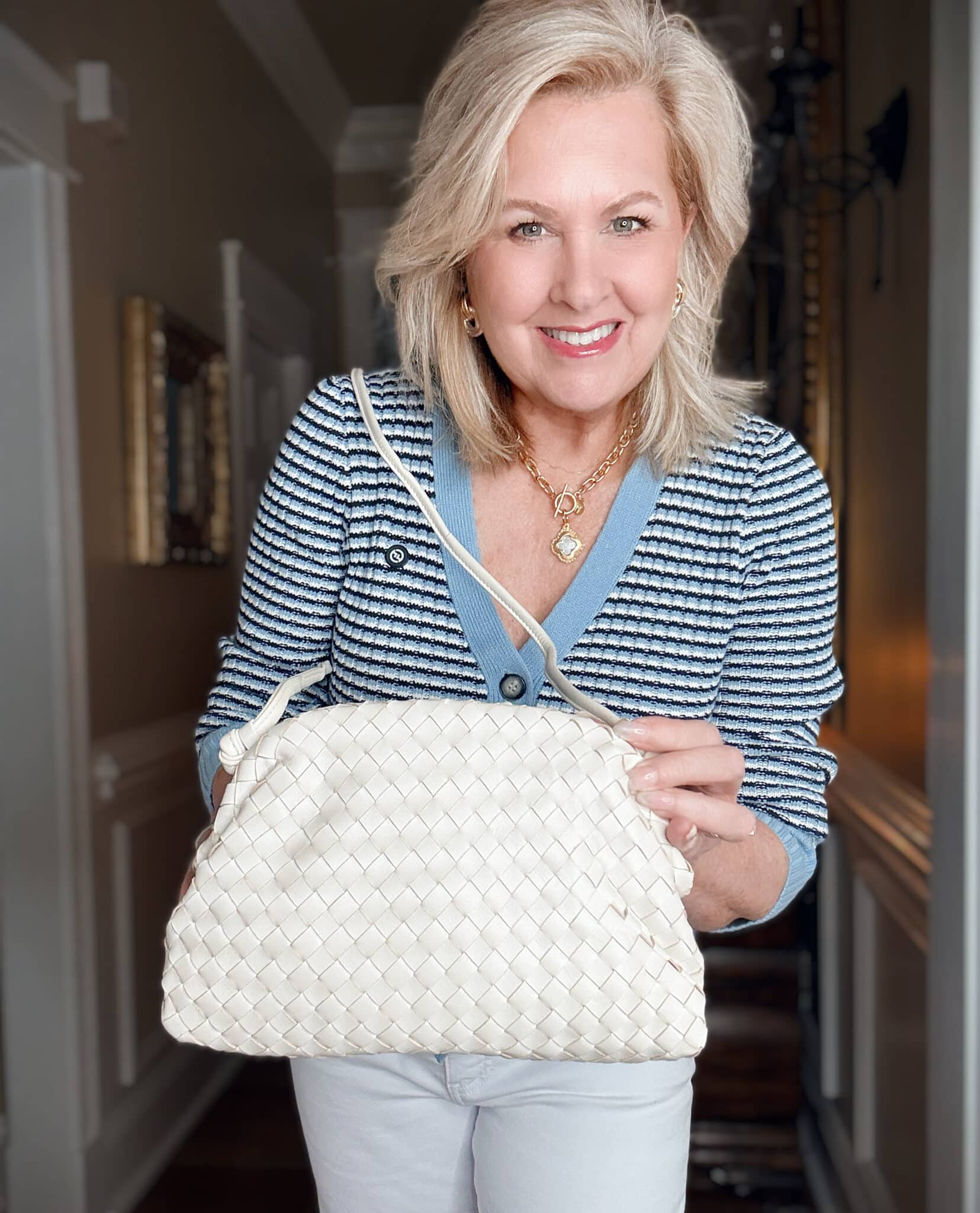 Tania wearing a striped cardigan with an ivory woven handbag from Quince