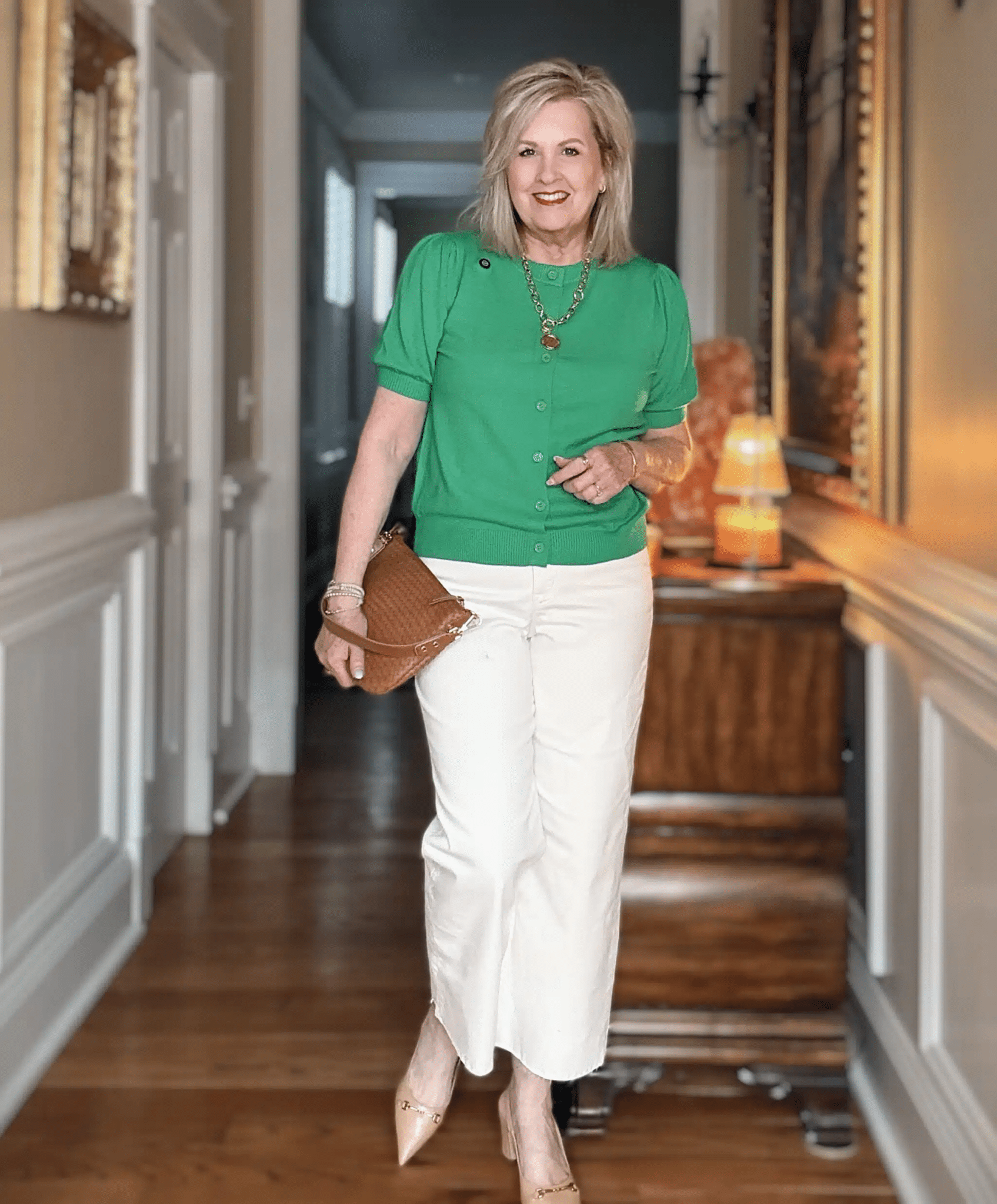 Tania is wearing a green puff sleeve cardigan and white frayed jeans