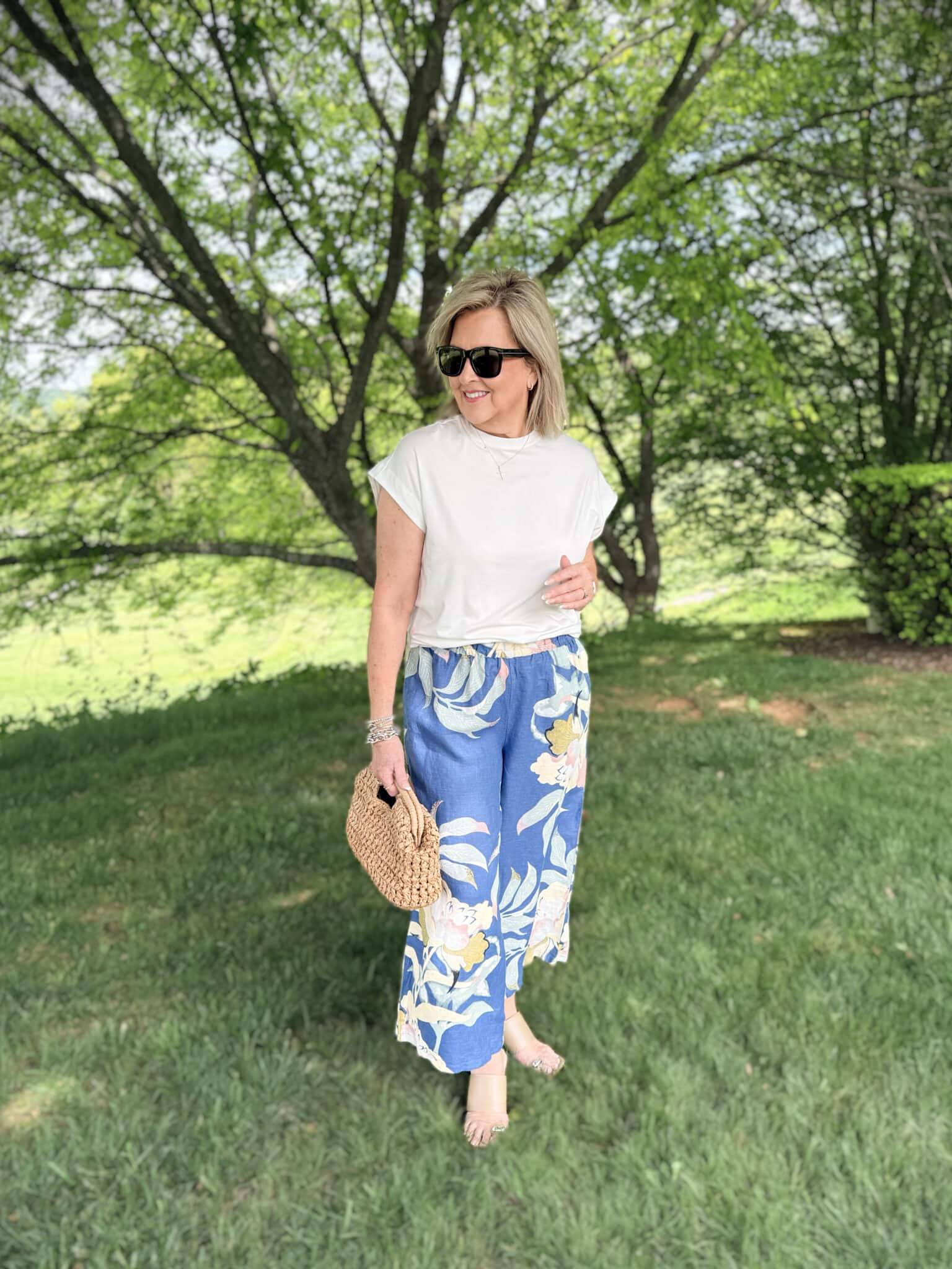 Tania wearing a white tee with cropped floral linen pants from Anthrpologie