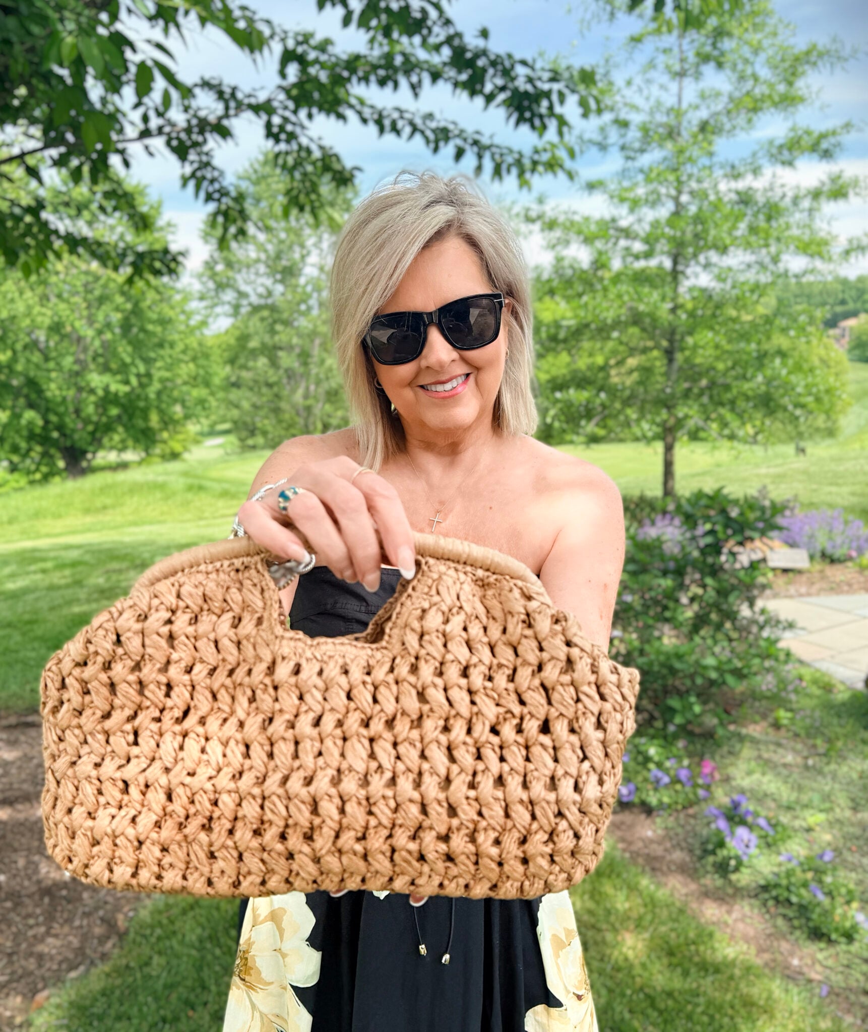 Tania wearing a black dress with a raffia handbag from Anthrpologie