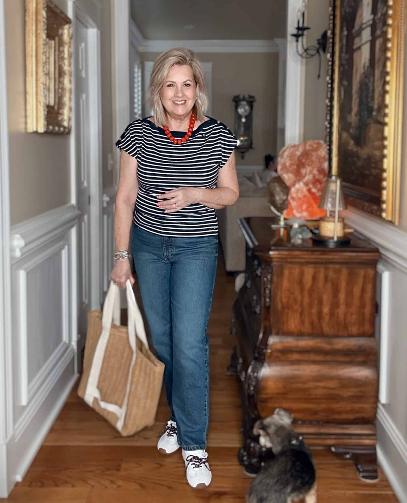 Tania wearing a striped navy top with straight leg jeans.