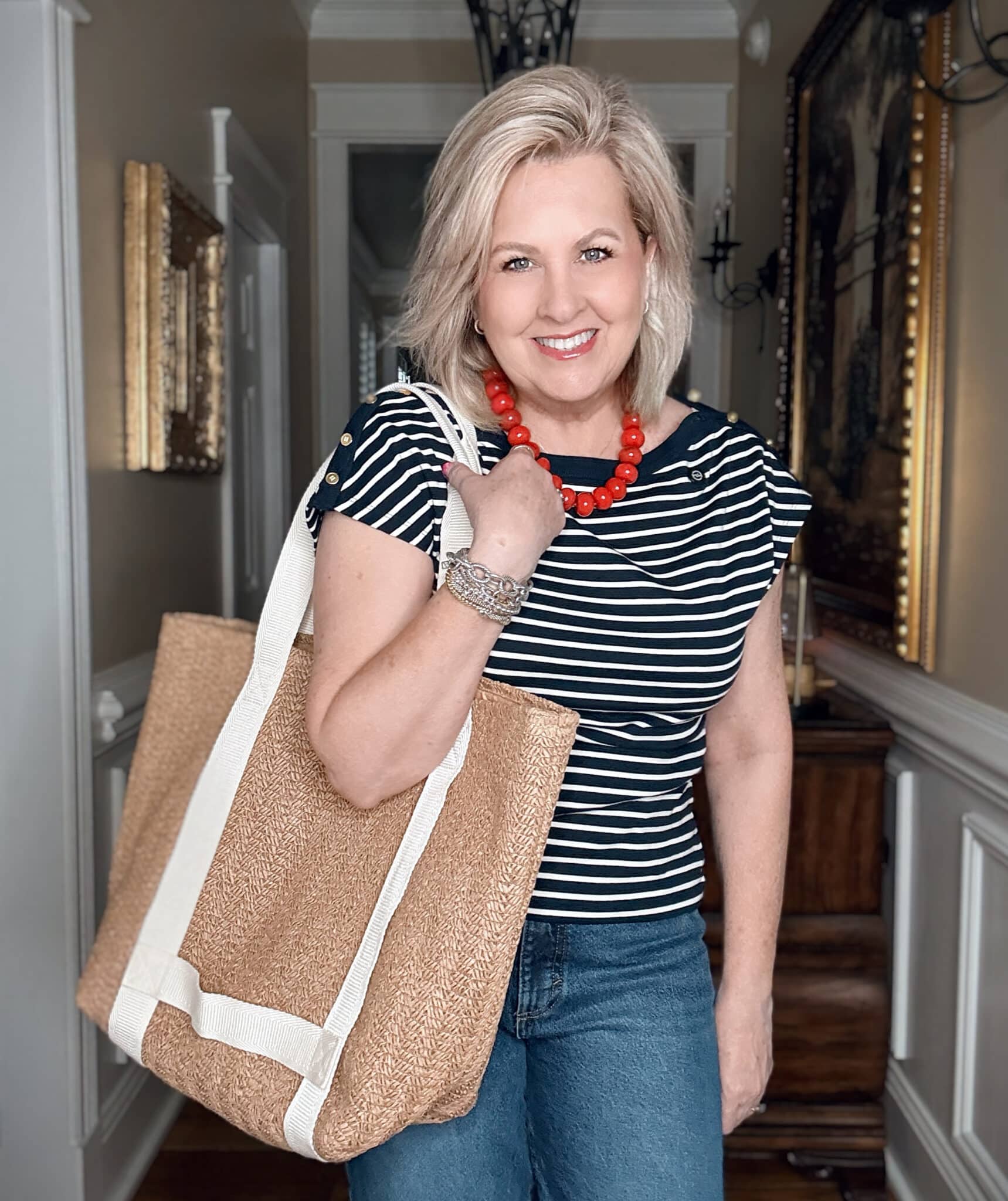 Tania wearing a striped navy top with a raffia beach bag