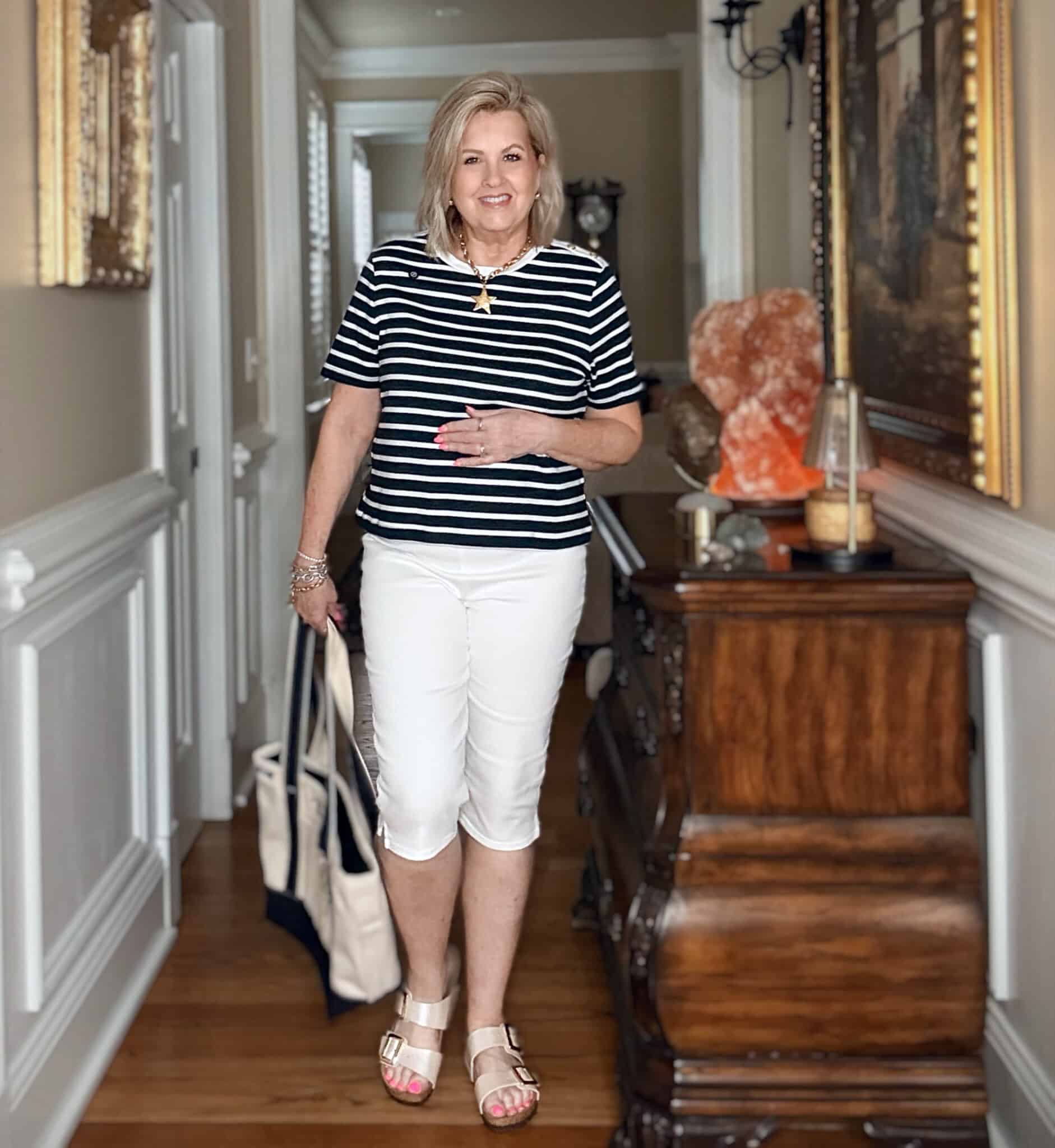 Tania wearing a striped white and navy top with white capri jeans