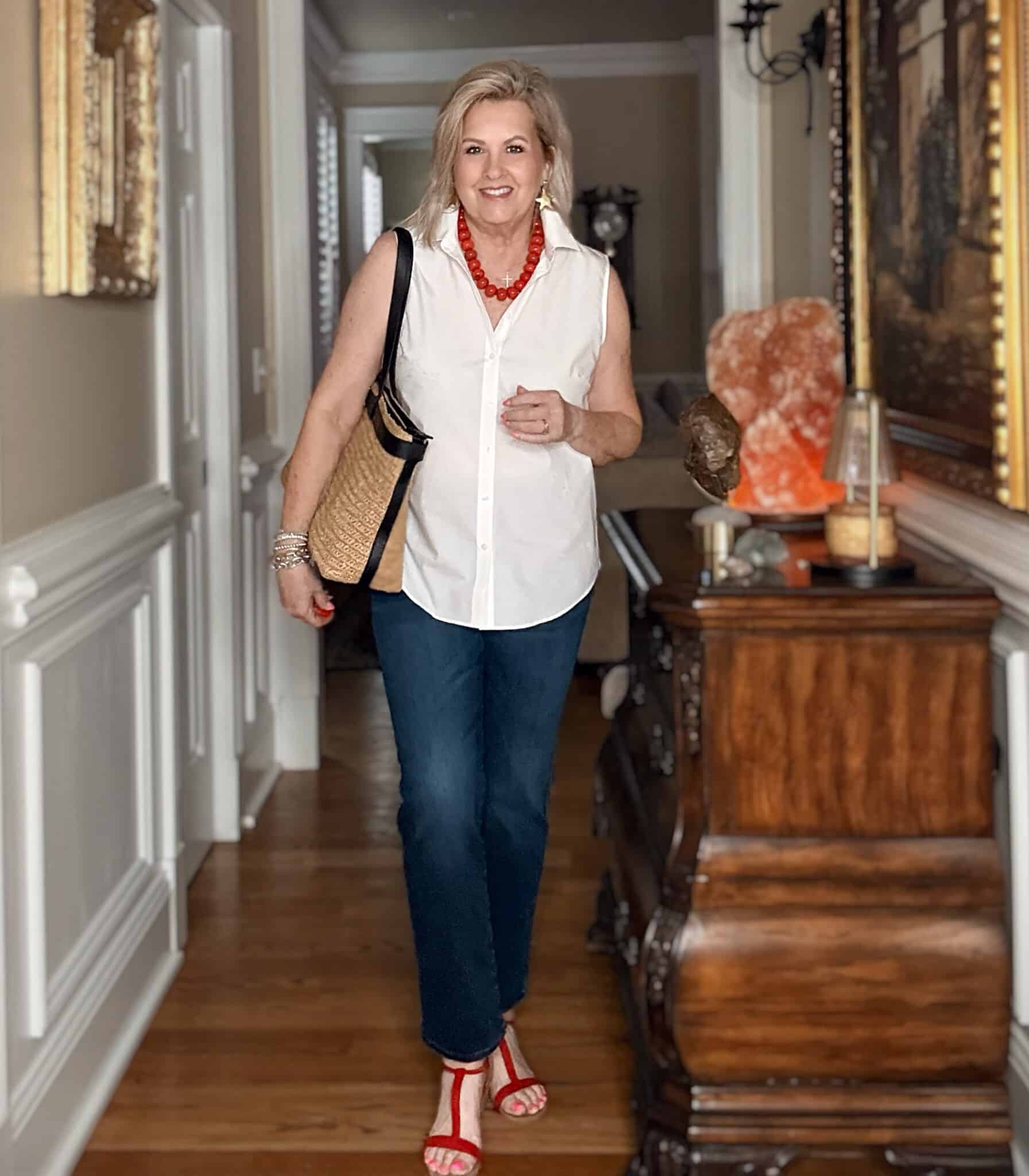 Tania wearing a sleeveless white shirt with dark wash jeans