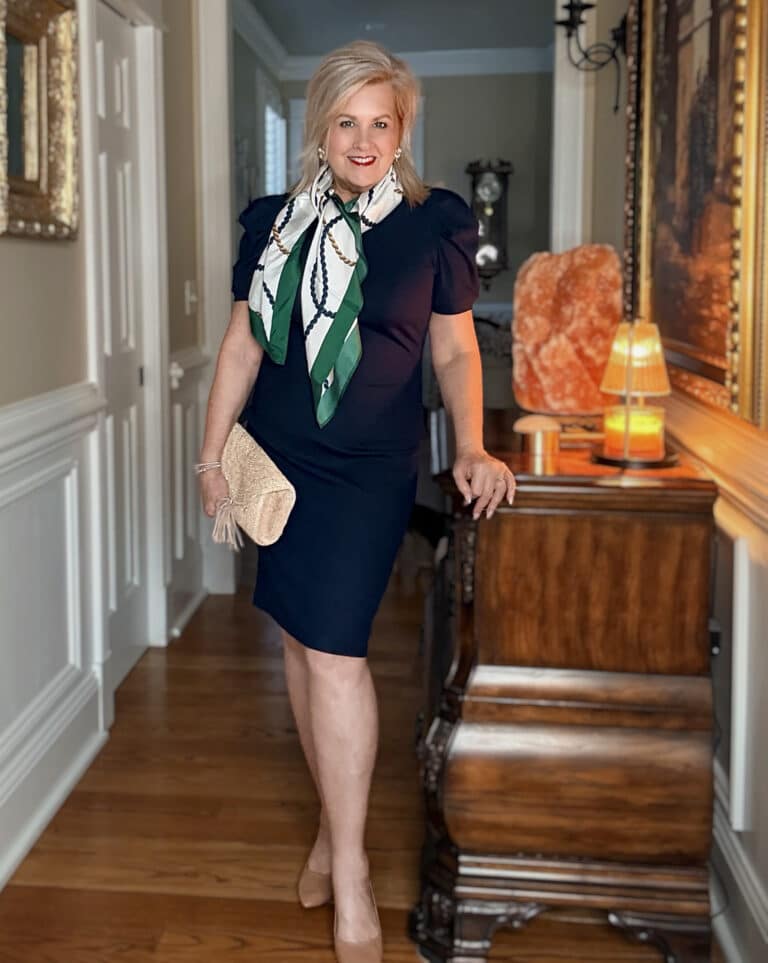 Tania wearing a navy, short sleeve dress with a rope silk scarf