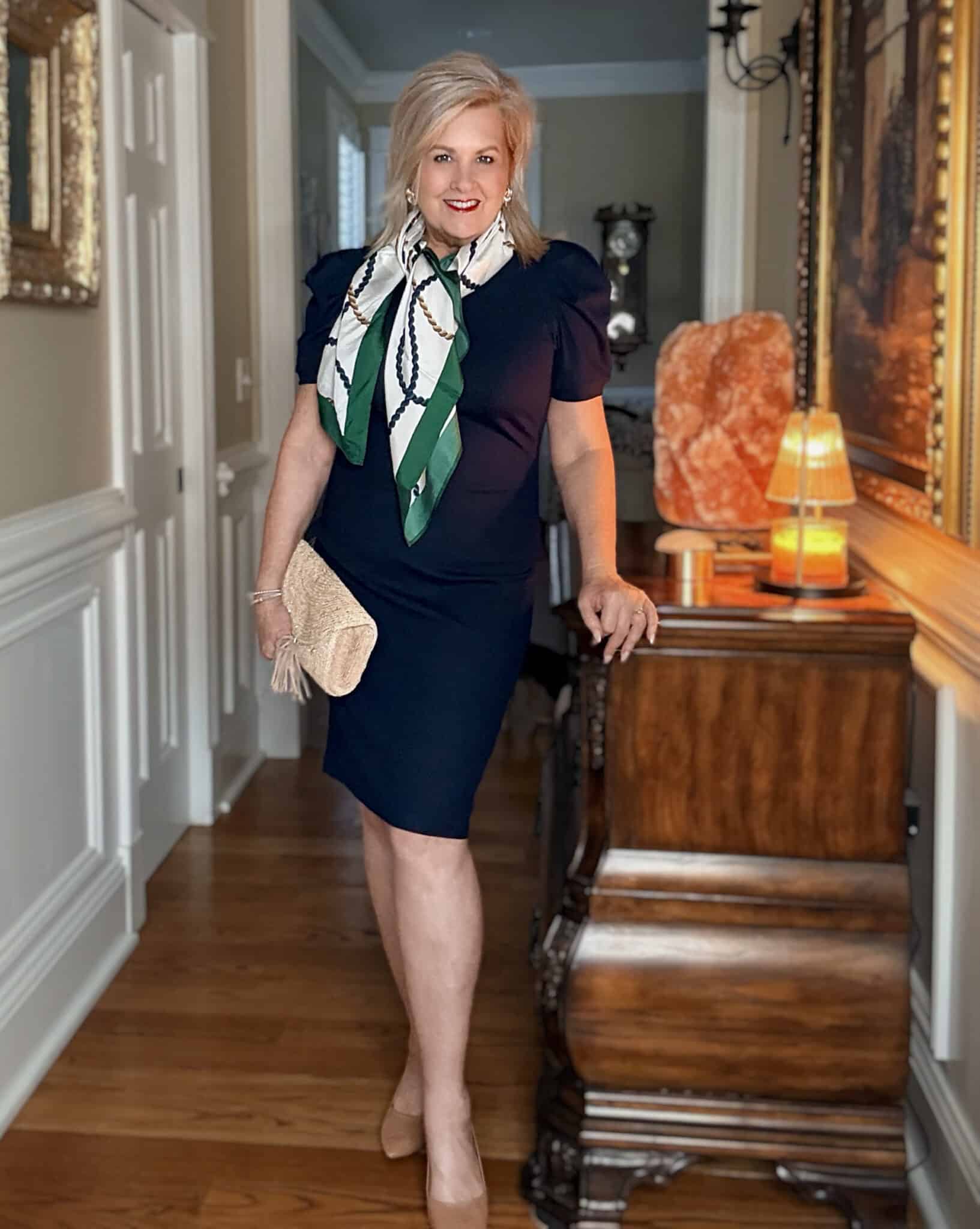 Tania wearing a navy, short sleeve dress with a rope silk scarf