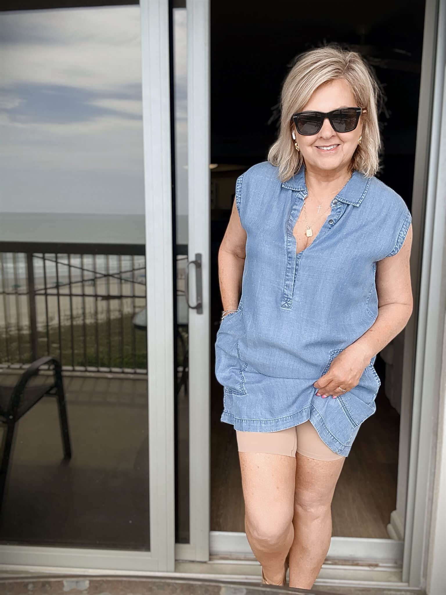 Tania wearing a chambray V-dress with thigh society shorts at the beach