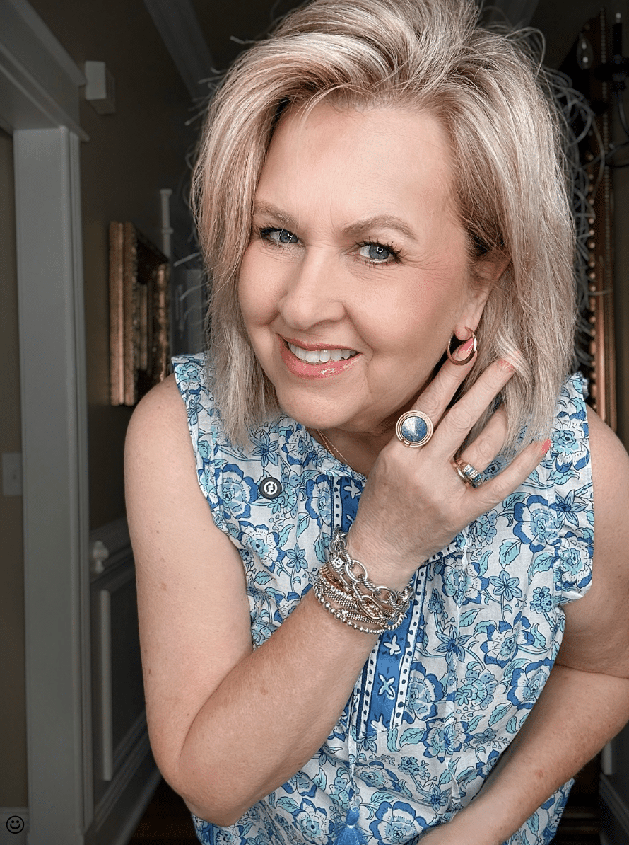 Tania wearing a printed blue shirt with gold earrings and a large blue ring