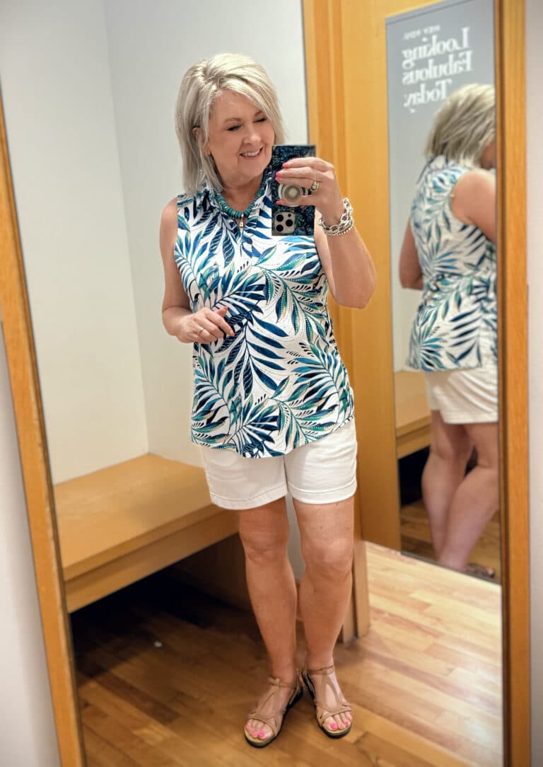 Tania wearing a sleeveless top on a palm print with white scalloped shorts from Chicos