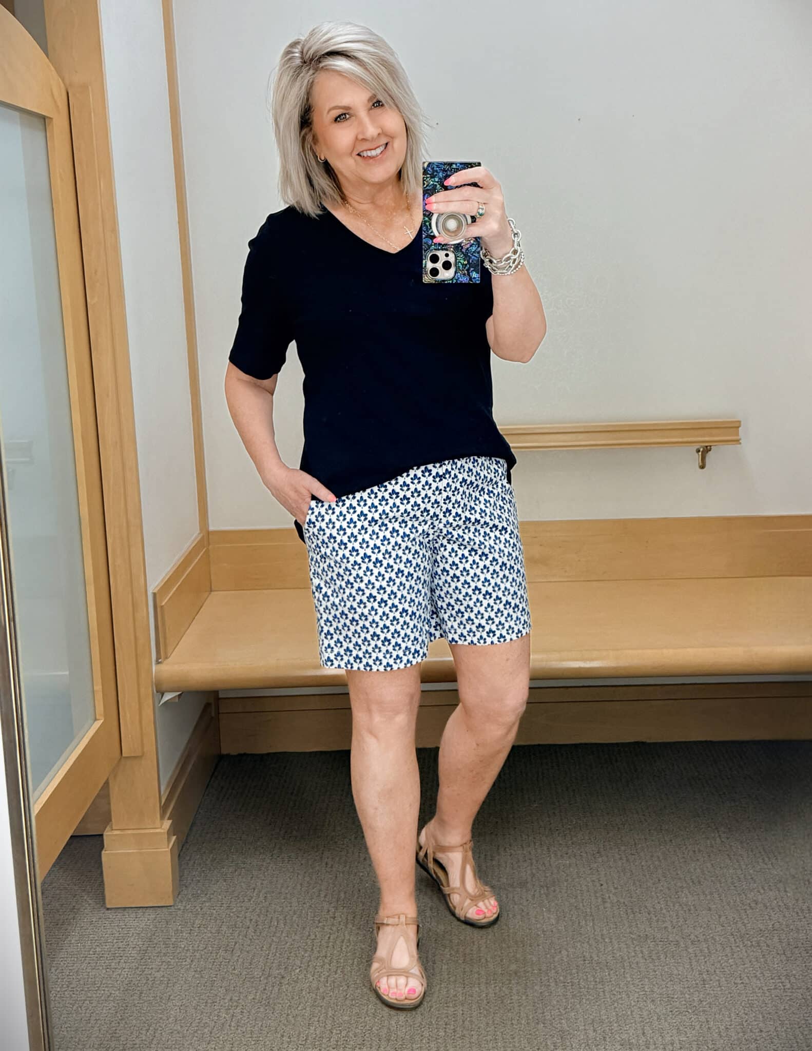 Tania wearing a navy v-neck tee with printed shorts
