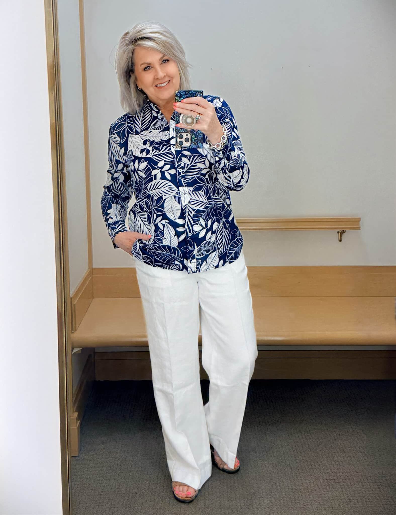 Tania wearing a navy and white floral button up shirt with white linen pants from Talbots
