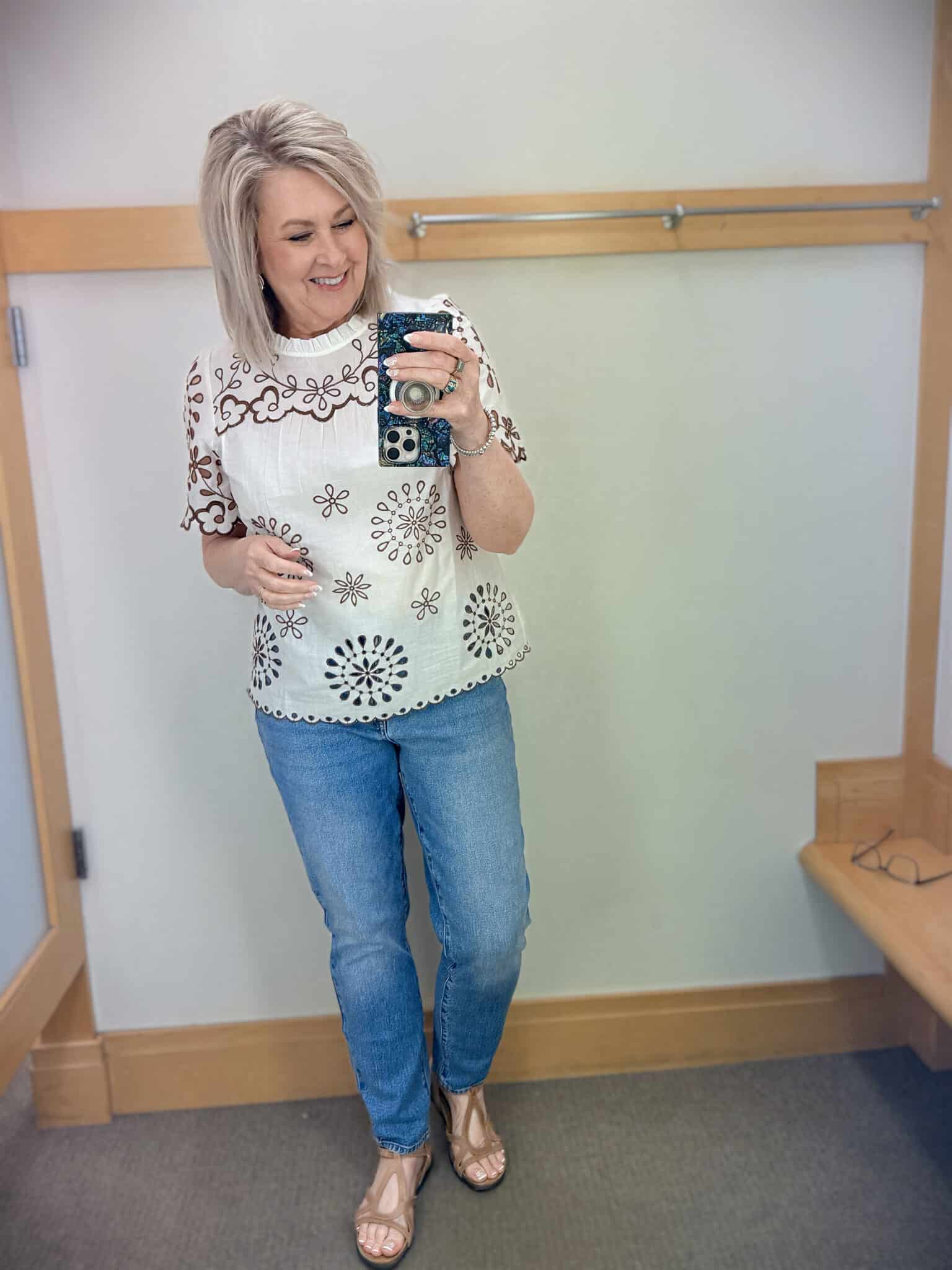 Tania wearing a white top with brown accents and straight leg jeans from Talbots