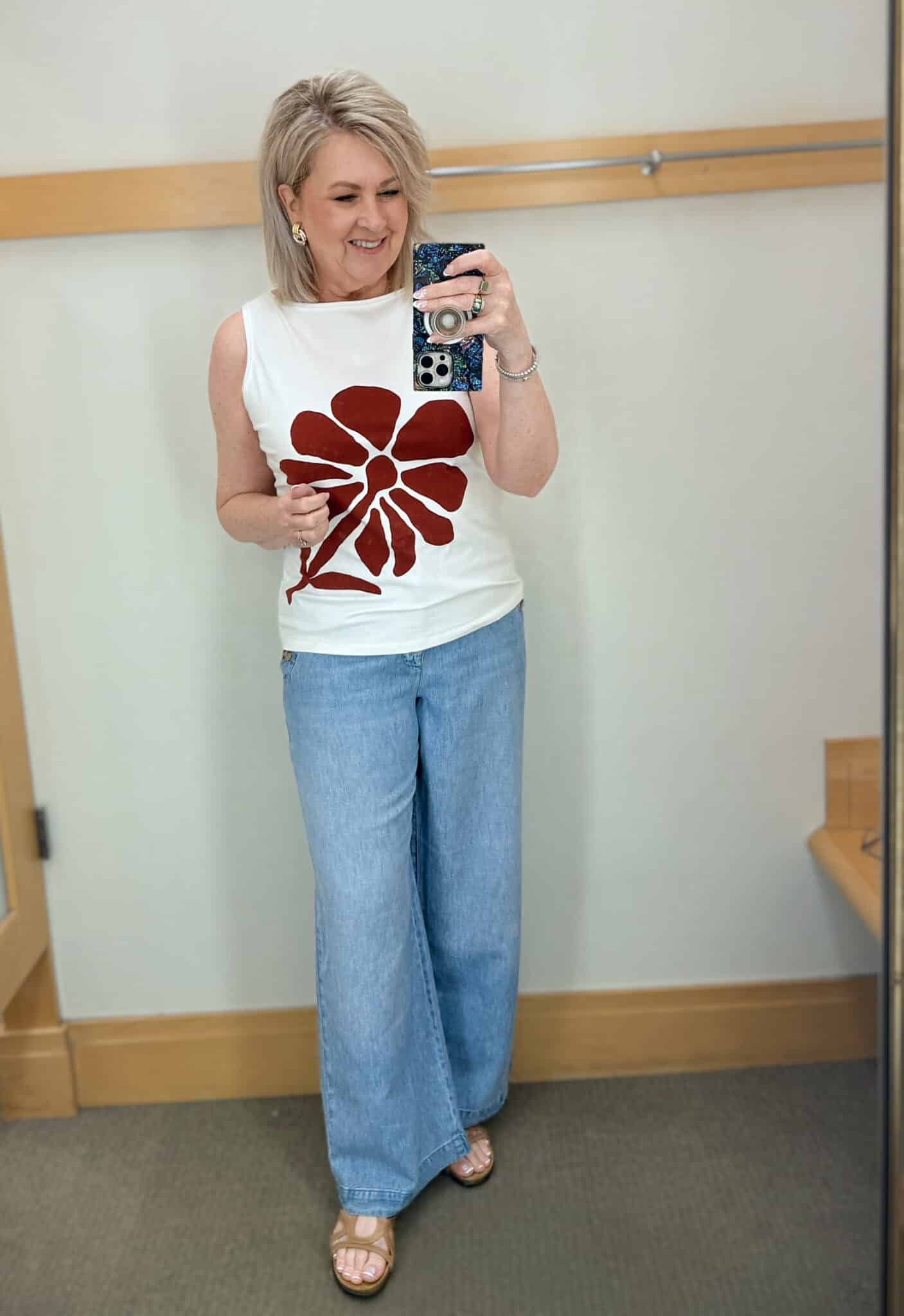 Tania wearing a white boatneck top with a floral design and wide leg sailor jeans from Talbots