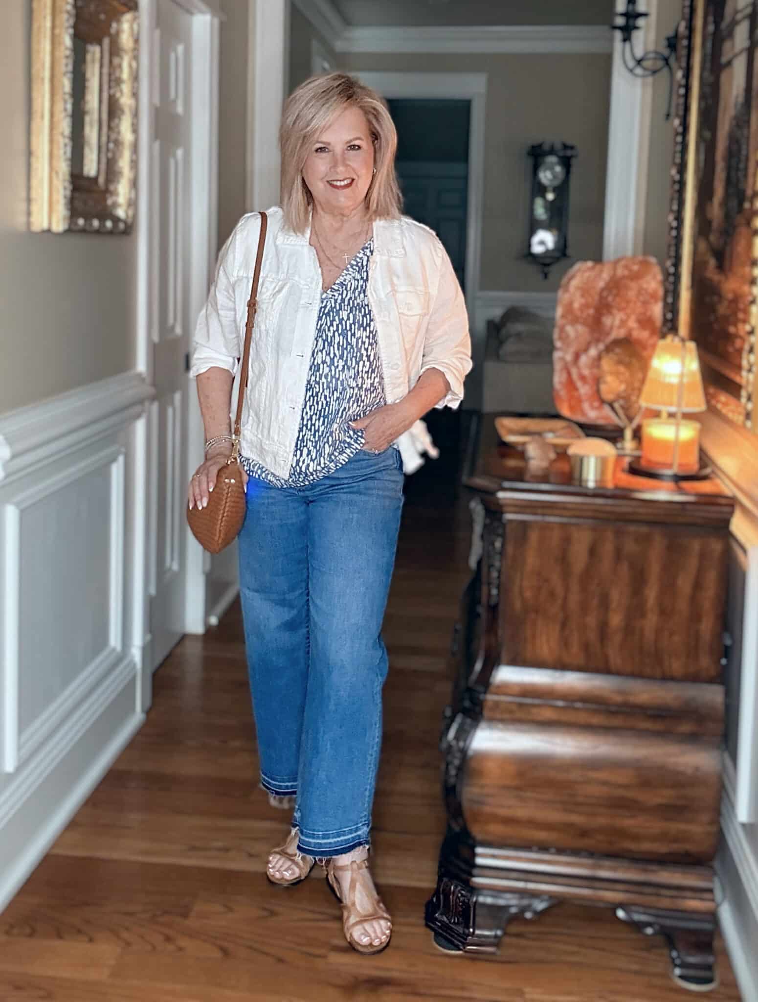 Tania wearing a linen jacket, a flowy top, and raw hem jeans from Tommy Bahama