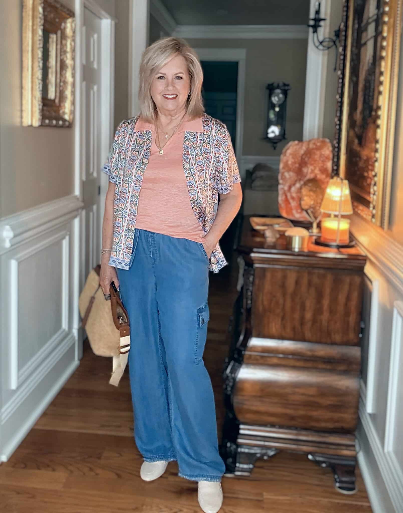 Tania wearing a mosaic camp shirt over a peach tank, with lightweight cargo pants from Tommy Bahama