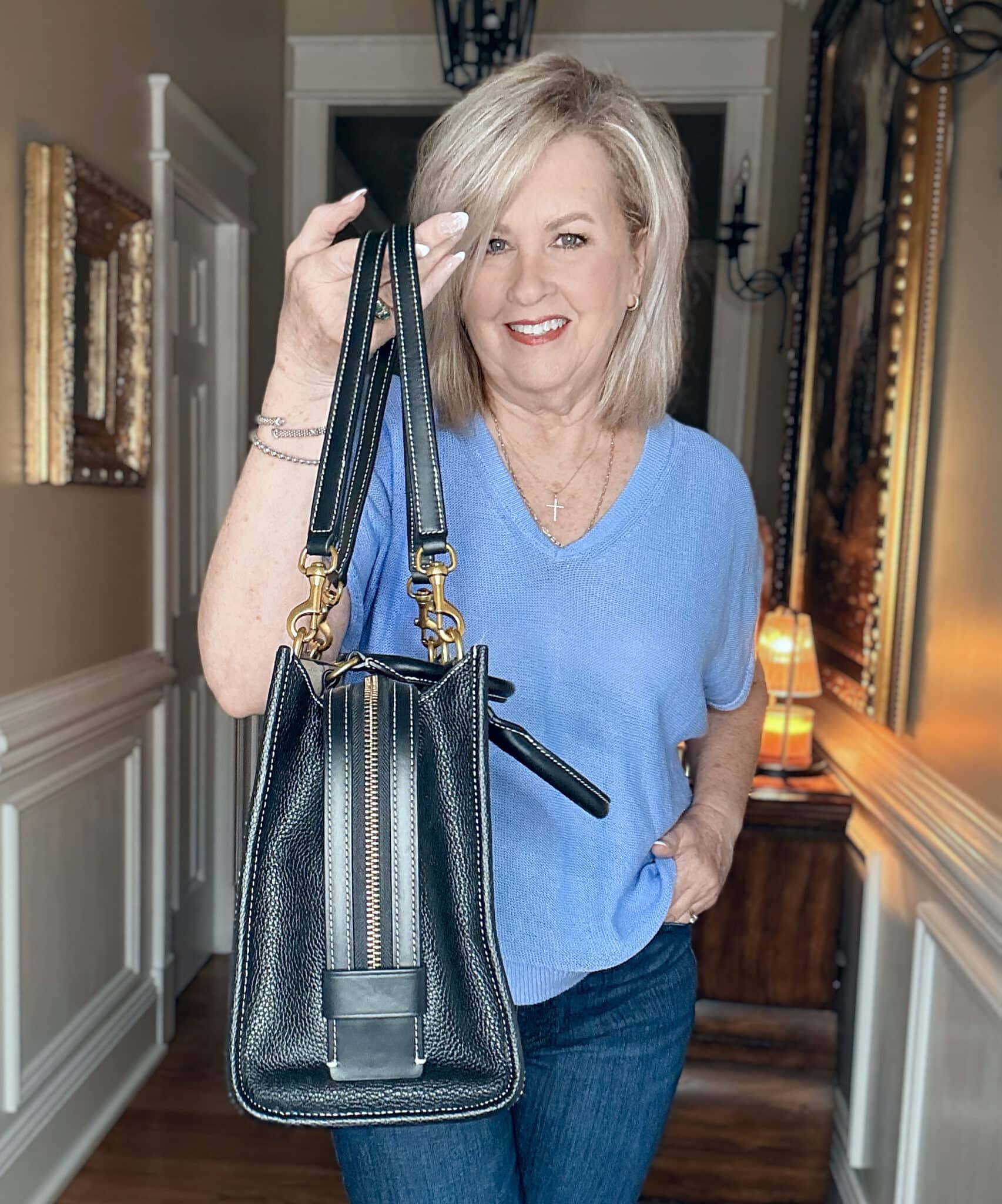 Tania showing the thickness of an Italian triple compartment handbag from Quince