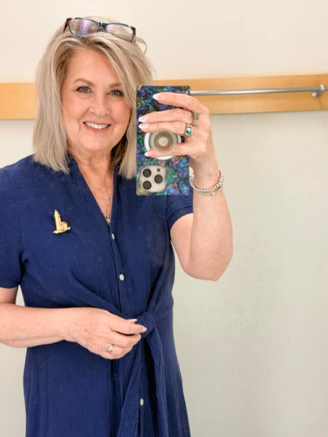 Tania wearing a lighthouse brooch on a navy gauze dress