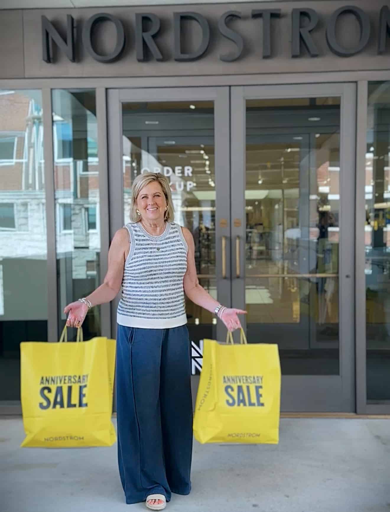 Tania holding two huge shopping bags from the Nordstrom Anniversary Sale
