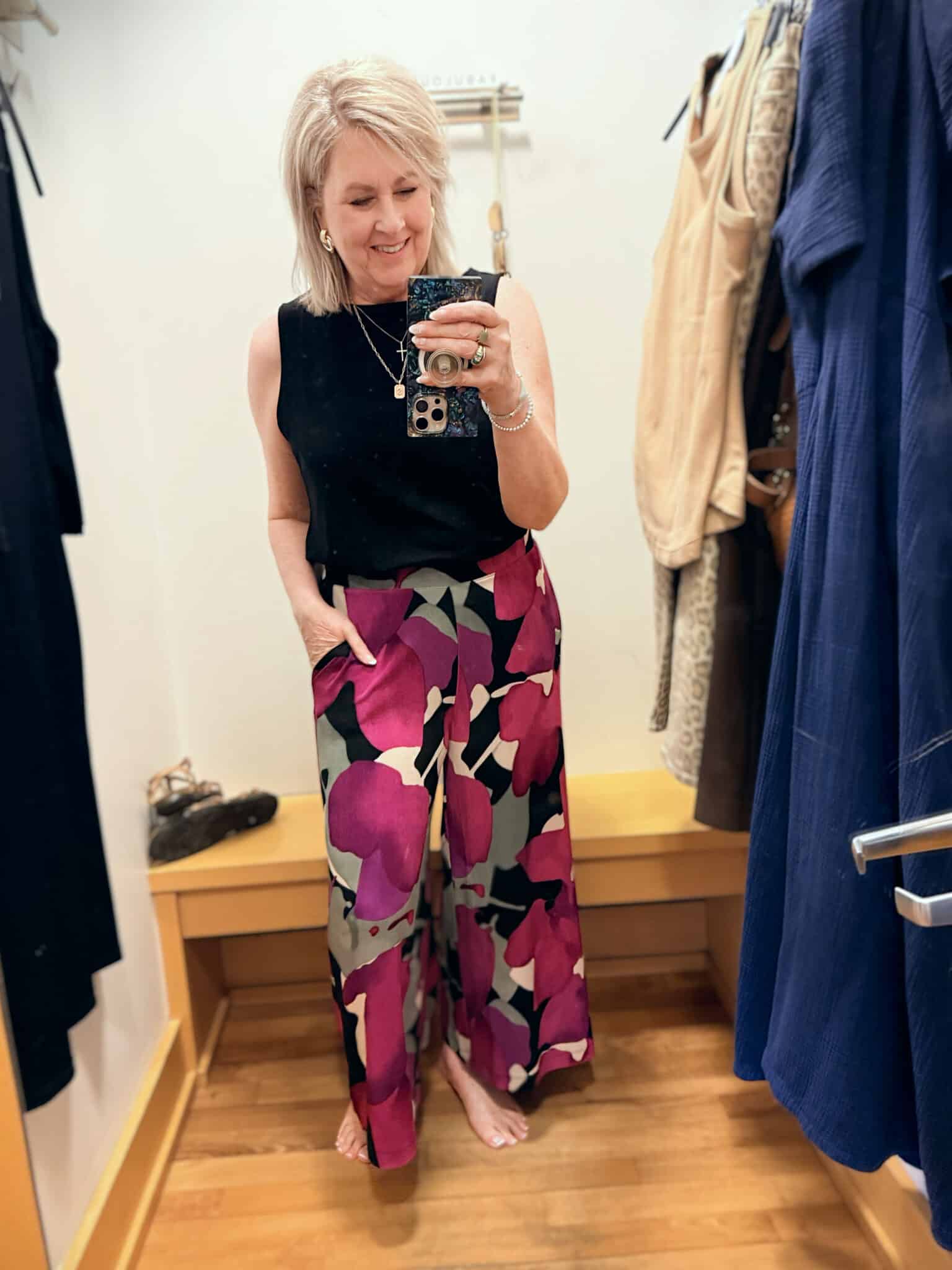 Tania wearing a black tunic tank tucked in to  brightly colored wide leg pants from the Zenergy line at Chico's