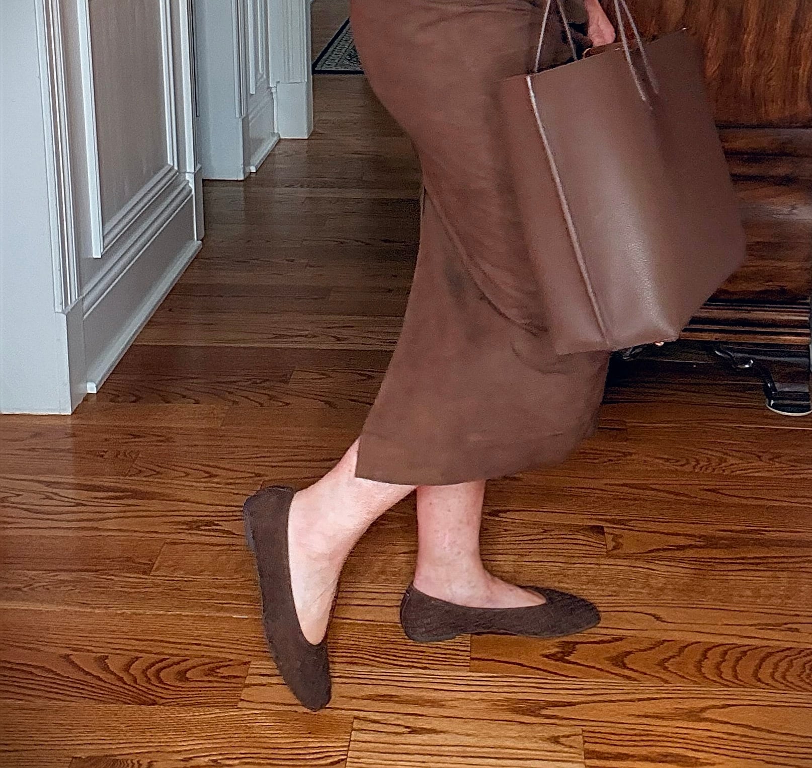 Tania wearing a brown cashmere sweater with a suede midi skirt with chocolate brown woven flats