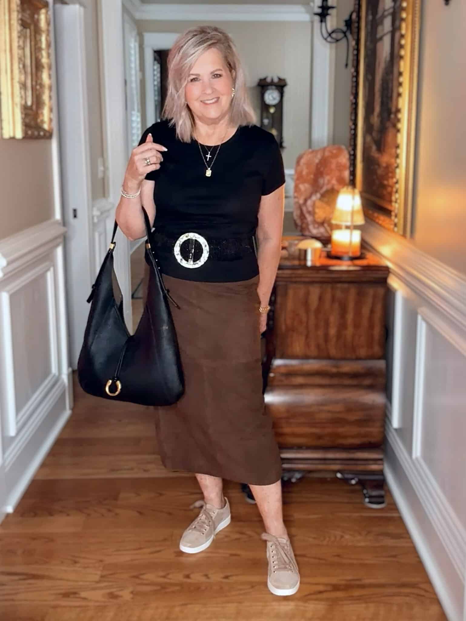 Tania wearing a black t-shirt with a suede midi skirt with suede lace up sneakers from Nordstrom