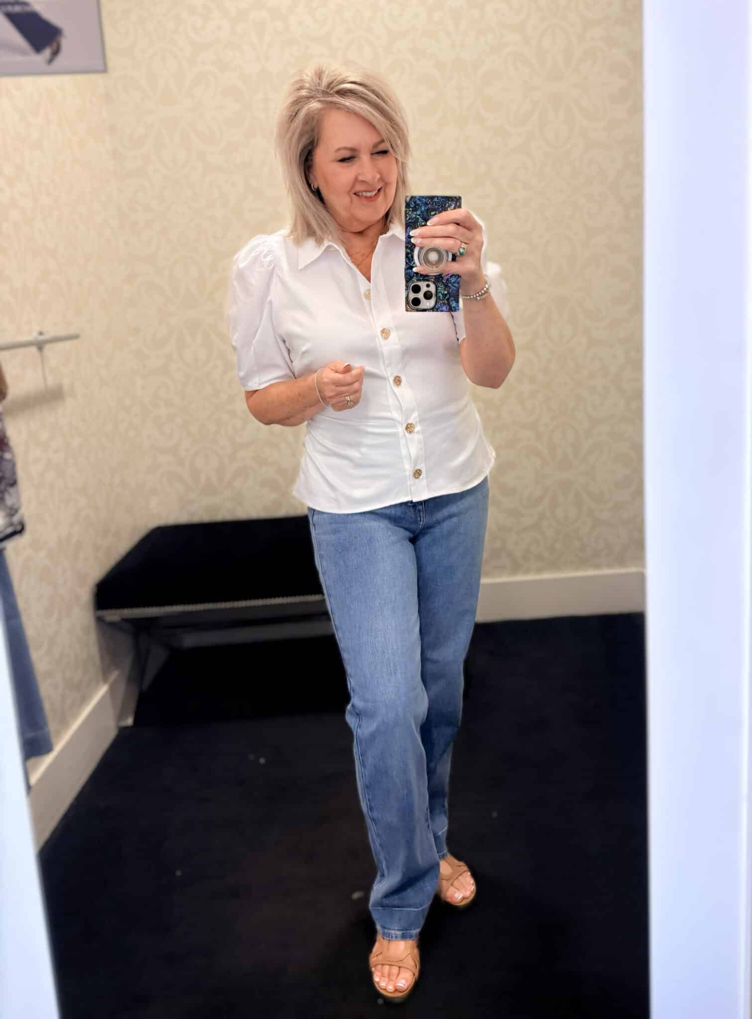 Tania wearing a white puff sleeve top with medium wash jeans from White House Black Market