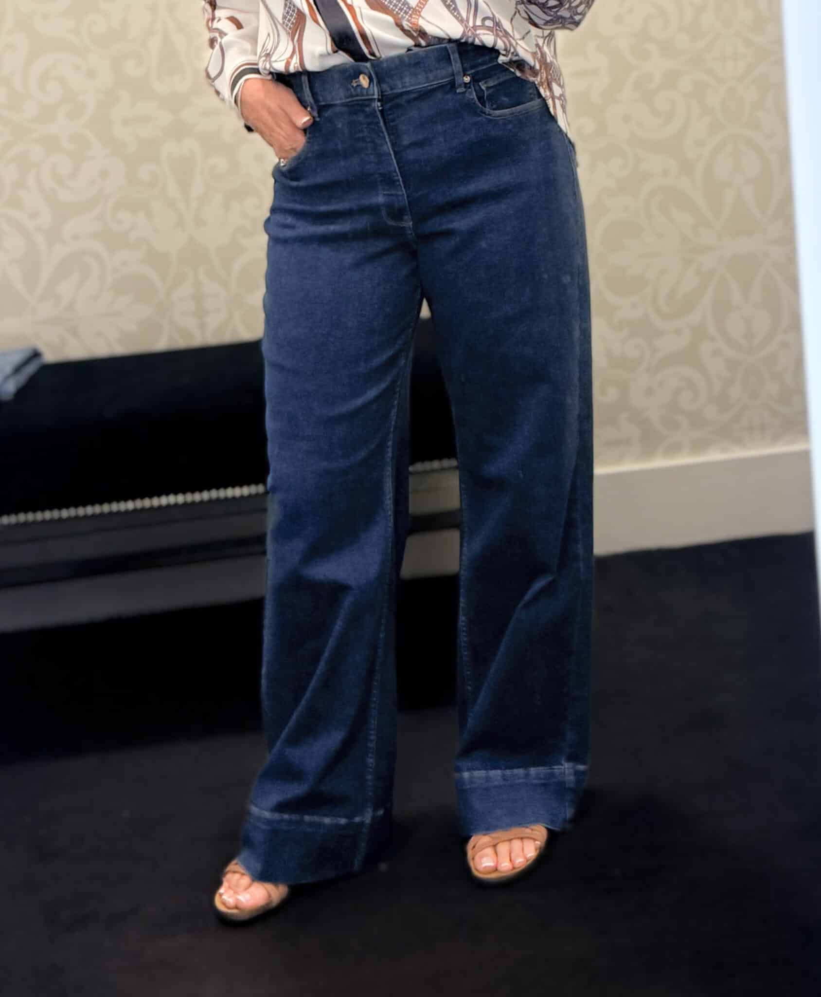 Tania wearing wide leg dark wash jeans from White House Black Market