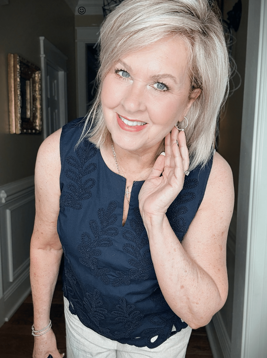Tania wearing a navy eyelet top with gold hoops