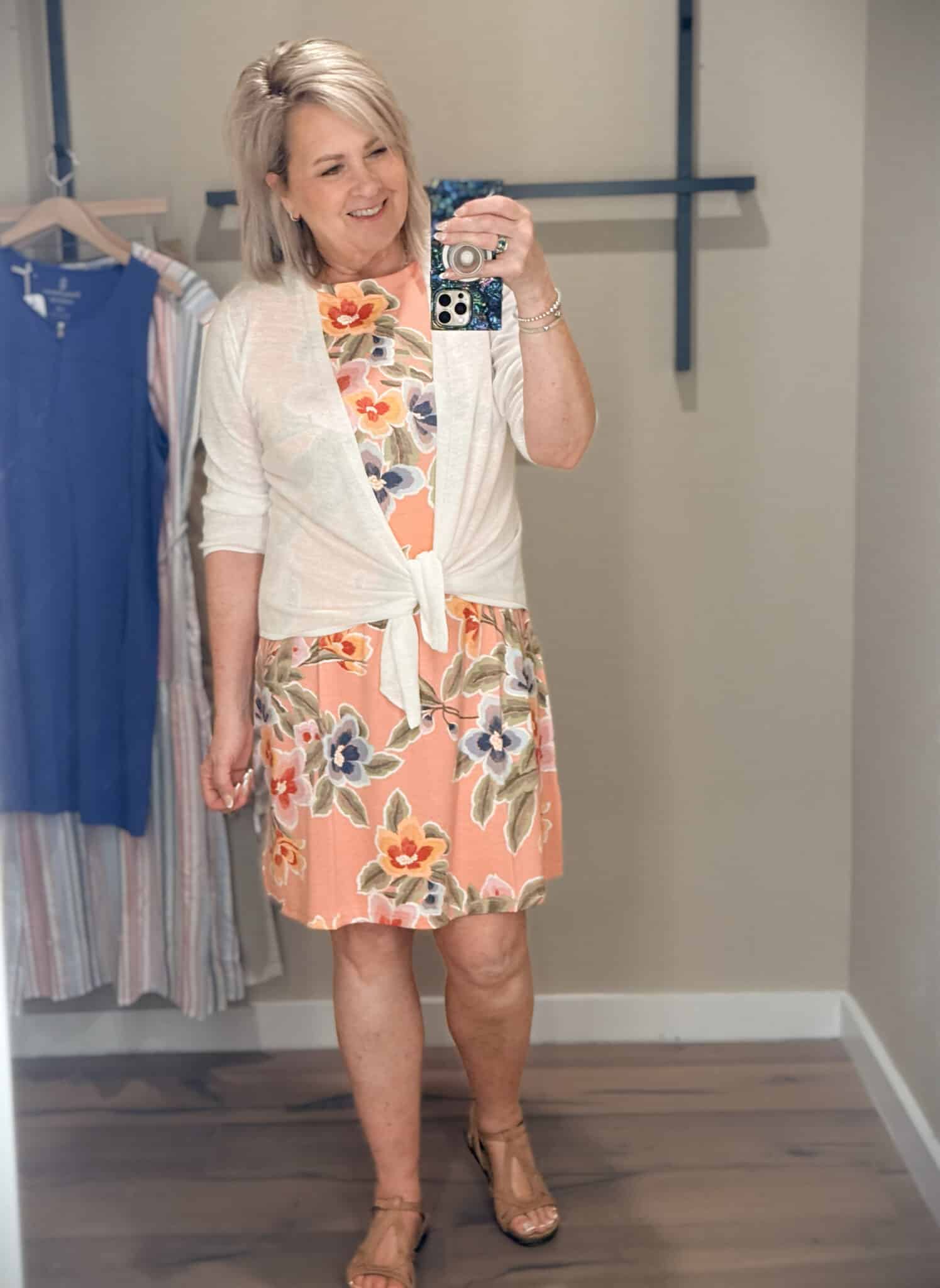 Tania wearing a floral peach tank dress with a tied white cardigan from Tommy Bahama