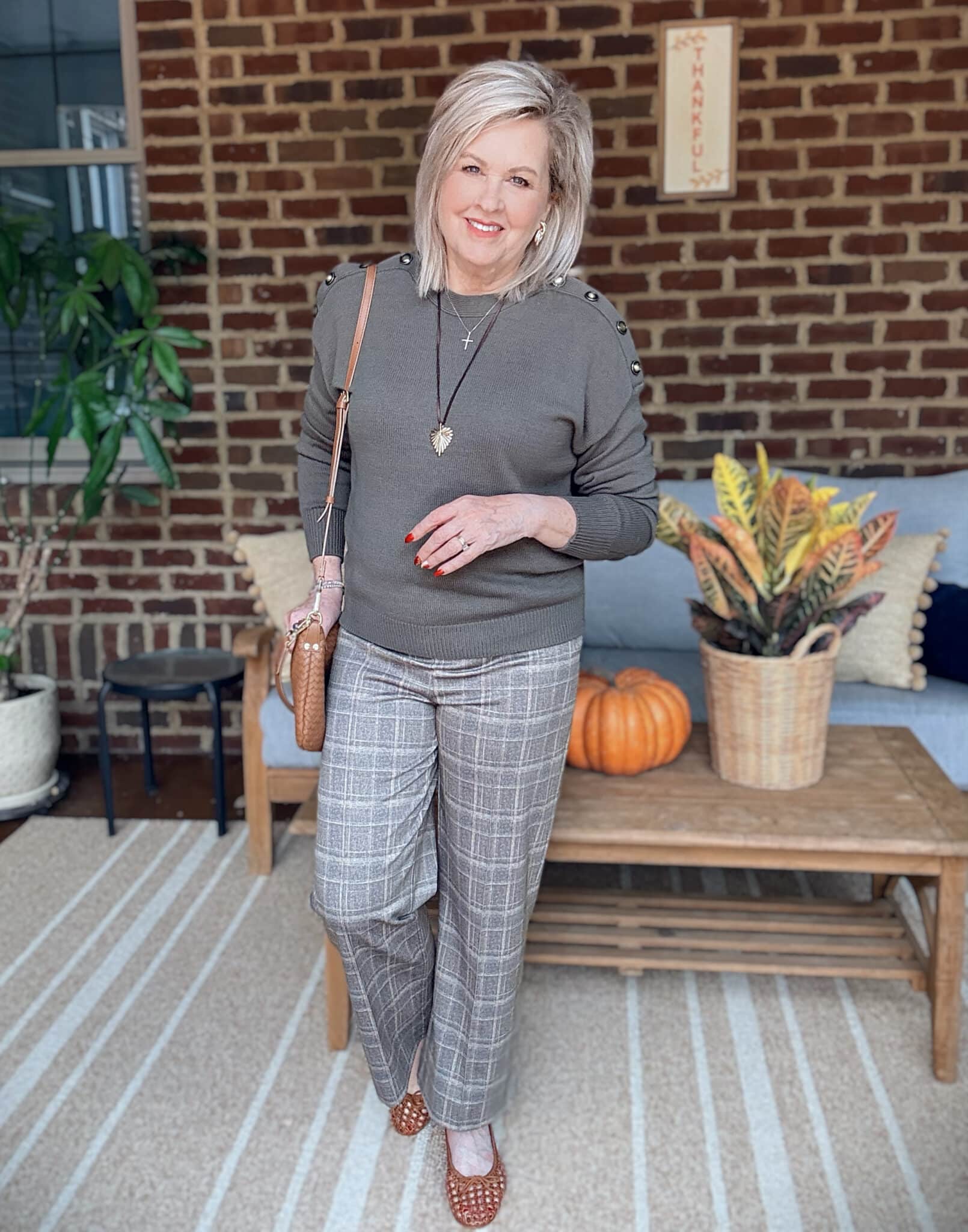 Tania wearing an olive sweater with plaid pants for fall