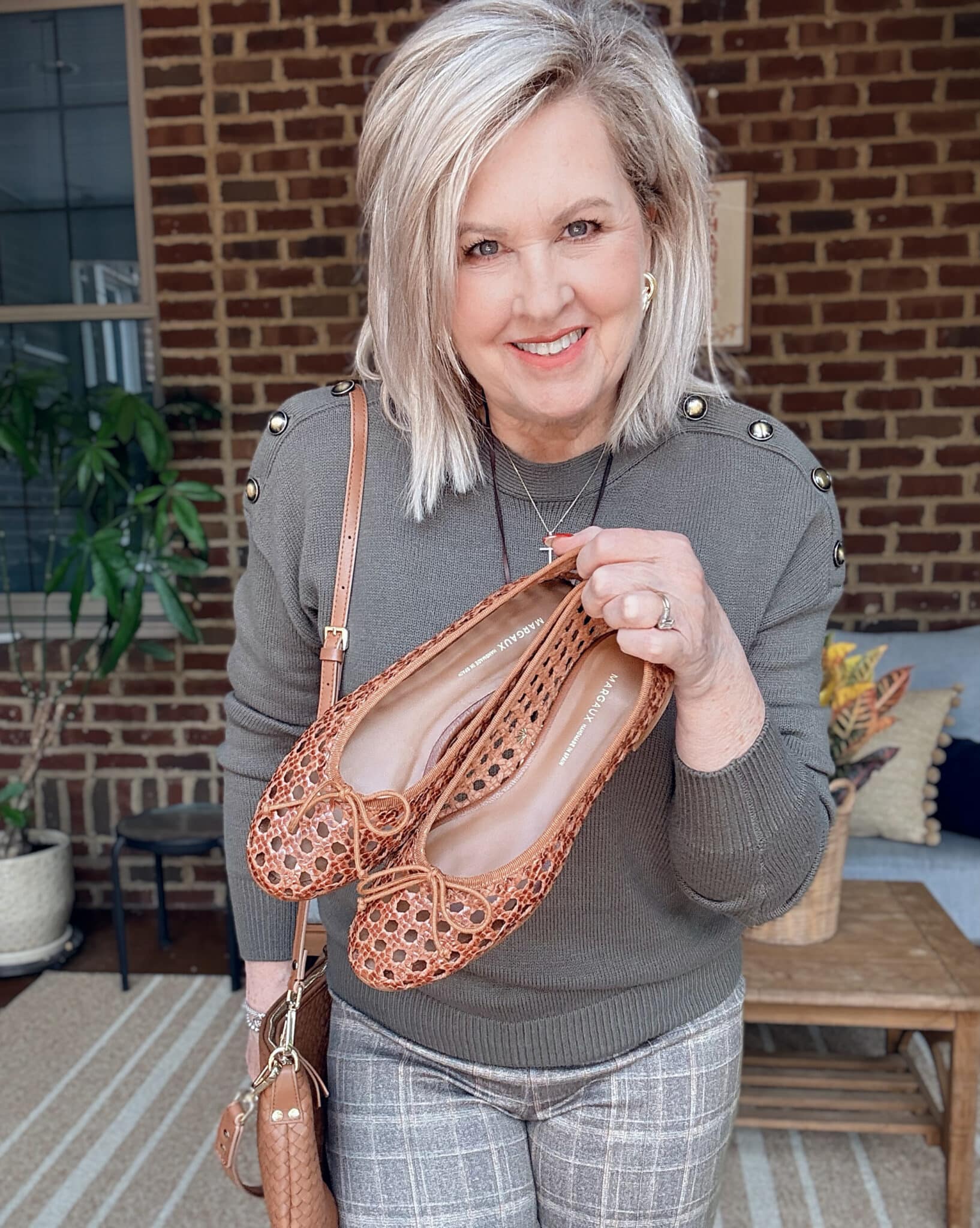Tania wearing an olive sweater with woven ballet flats