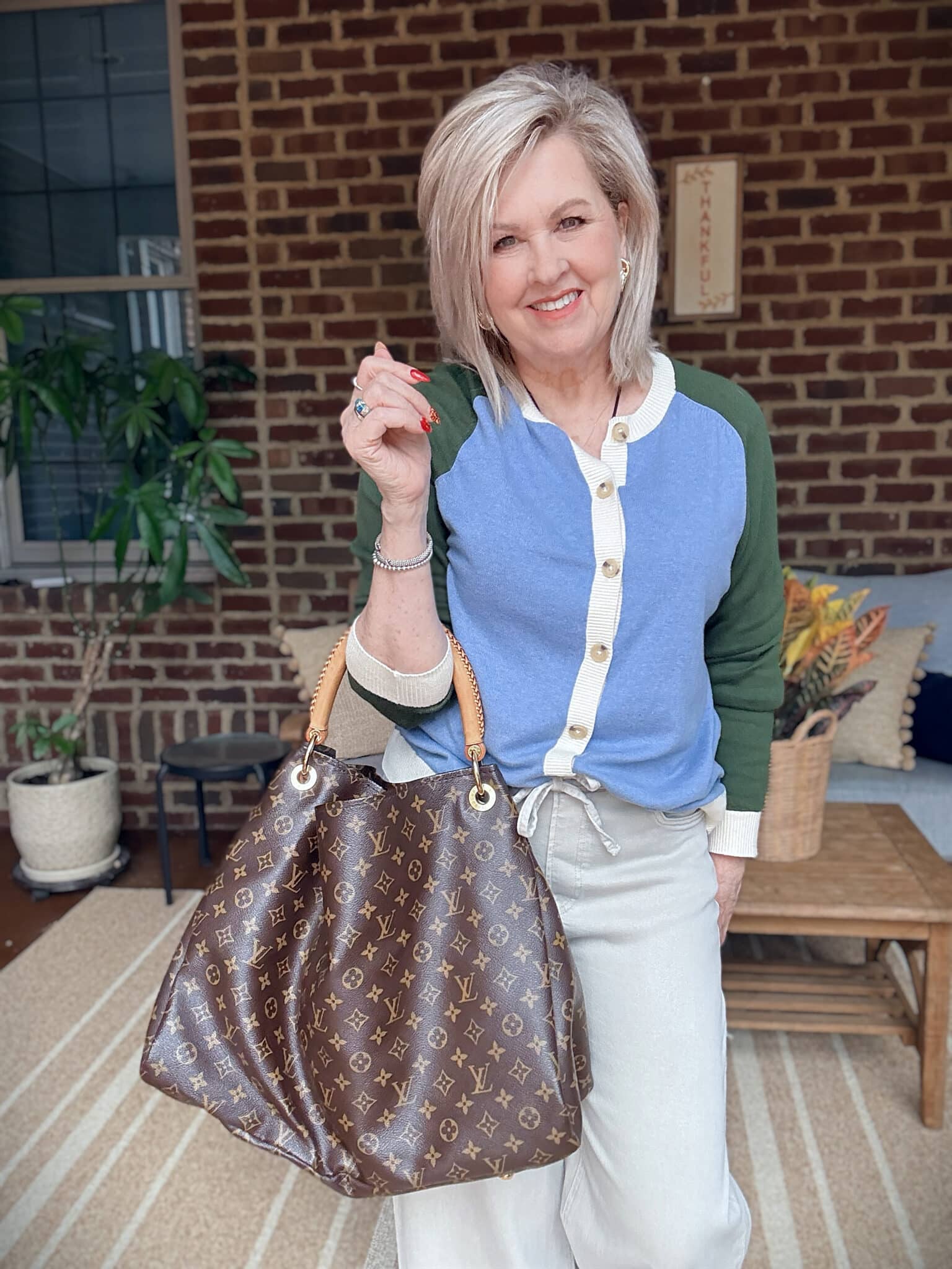 Tania wearing a colorblock sweater with an Arty handbag