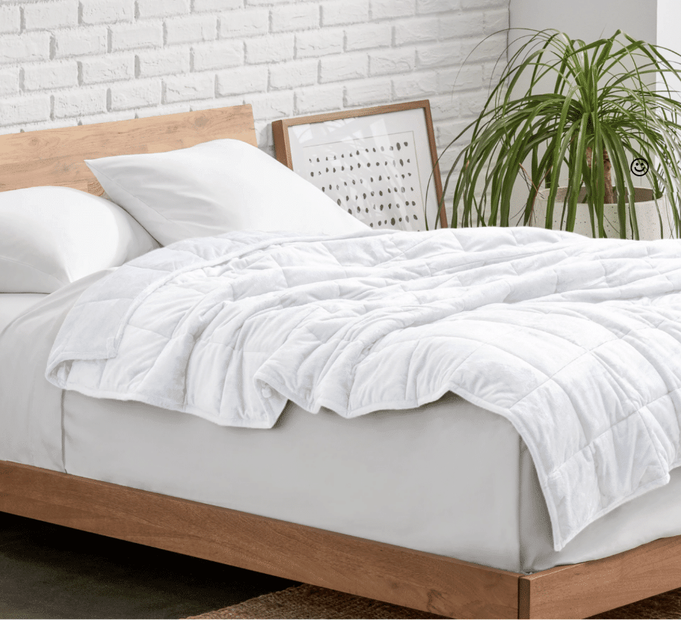 bed with a white Minky Fleece Weighted Blanket on it