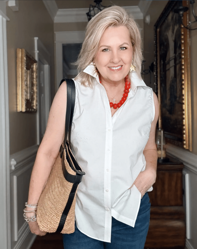 Tania wearing a sleeveless white shirt with a large red necklace