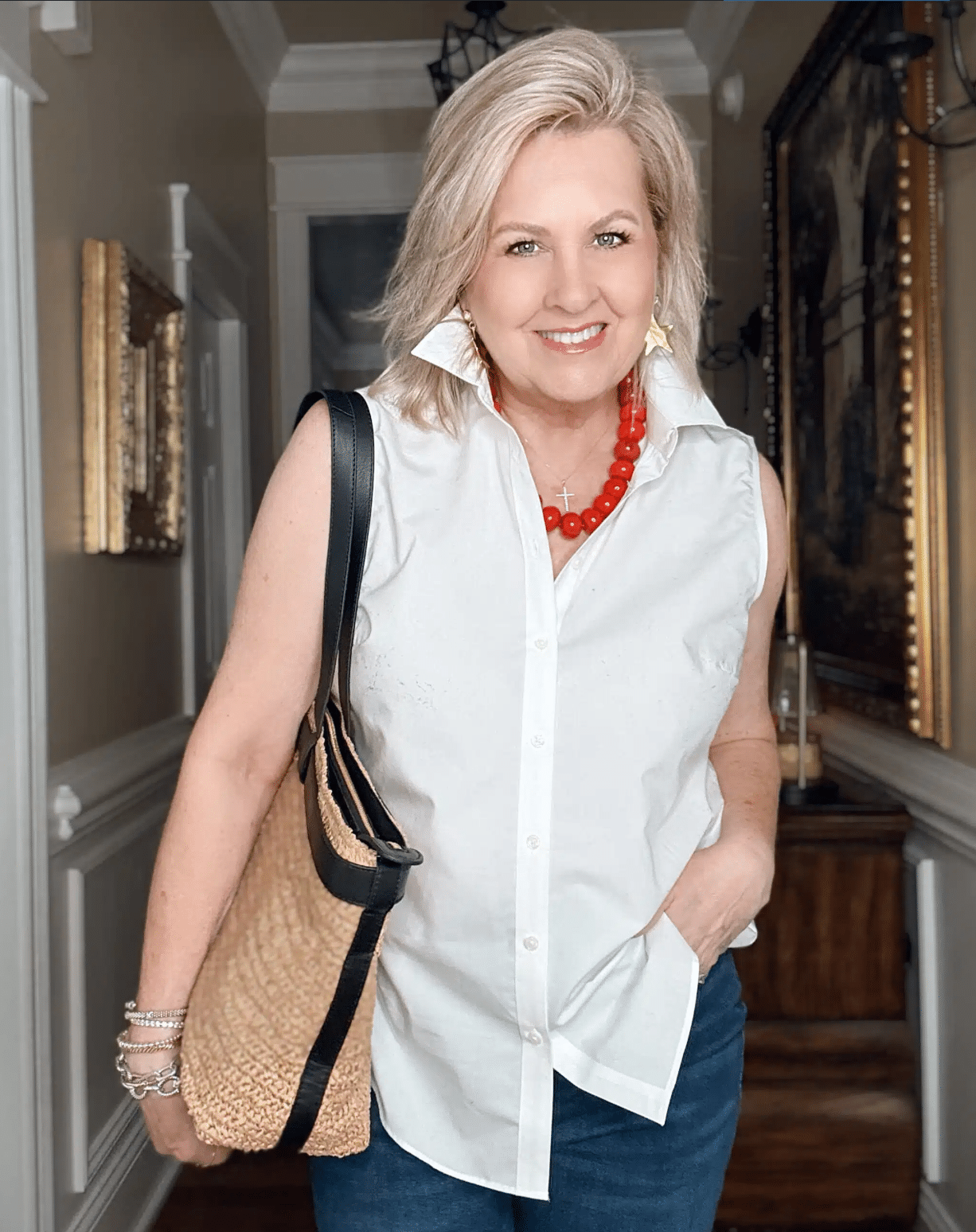 Tania wearing a sleeveless white shirt with a large red necklace