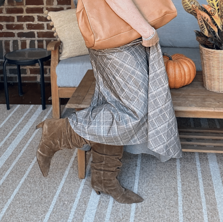 Tania wearing a pleated olive skirt and brown boots for fall