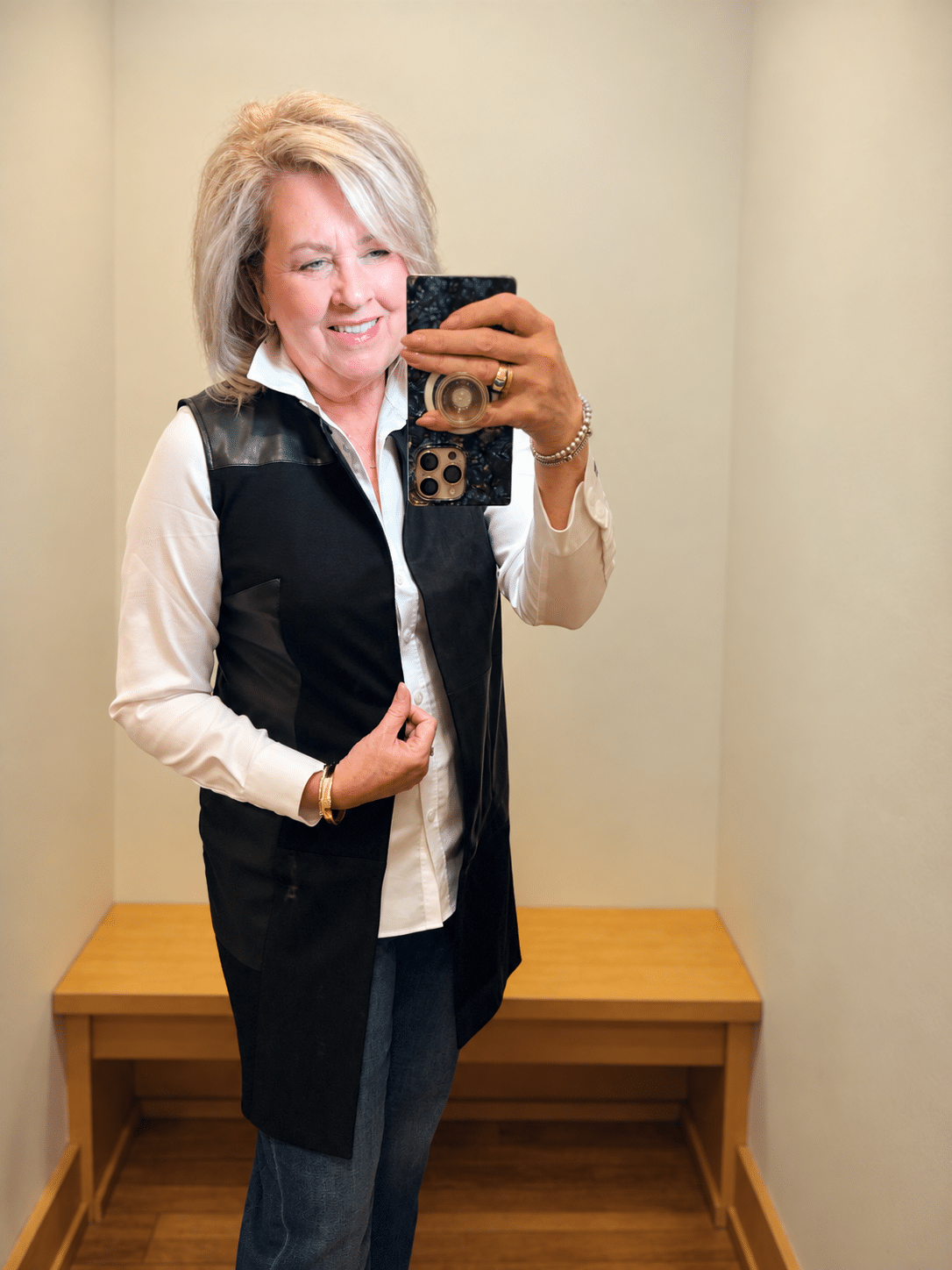 Chico’s faux suede long black vest layered over a white no-iron button-down shirt.