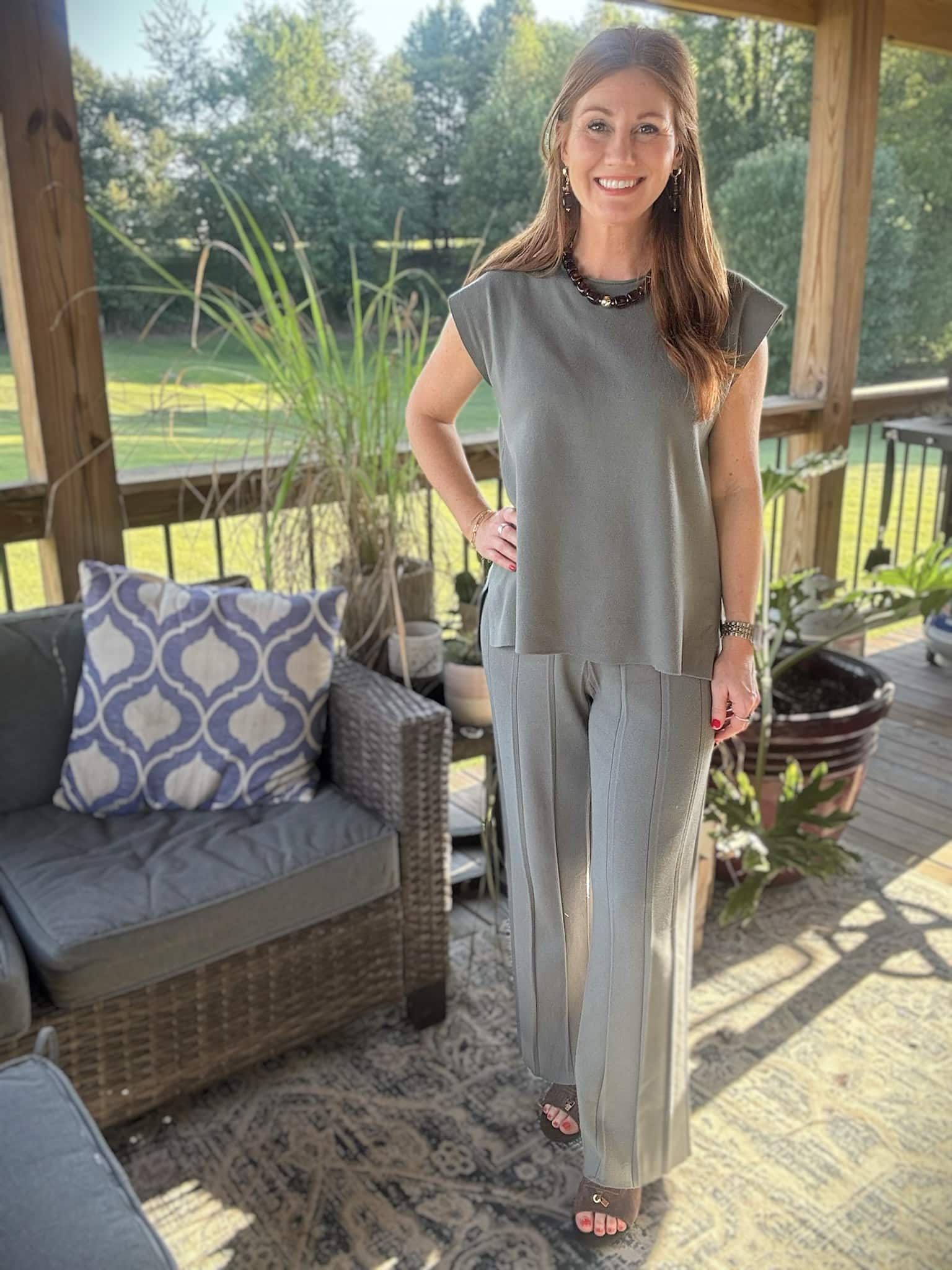 Petite woman wearing a two-piece cap sleeve top and wide-leg pleated pants outfit for fall